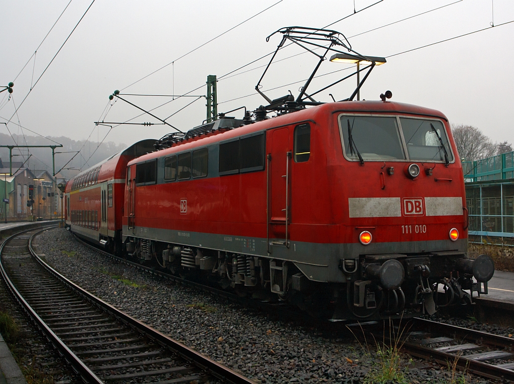 111 010-5 als Schublok des RE 9 (rsx - Rhein-Sieg-Express) Siegen - Köln - Aachen am 18.11.2012 beim Halt im Bahnhof Betzdorf/Sieg.
Von den Loks der Baureihe 111 wurden zwischen 1974 bis 1984 insgesamt 227 Stück von verschiedenen Herstellern (AEG, BBC, Henschel, Krauss-Maffei, Krupp, Siemens) gebaut, 222 Stück sind noch im Bestand der DB.
Sie haben die Achsformel Bo'Bo', die Länge über Puffer ist 16.750 mm. Sie haben 4 Fahrmotoren á 905 kW = 3.620 kW Leistung, welche die 83 t schwere Lok, bei einer Anfahrzugkraft von 274 kN, auf eine Höchstgeschwindigkeit von 160 km/h bringen.

Teilweise, wie hier, haben Lok der 1. Bauserie einen Scheren-Stromabnehmern der Bauart DBS 54a (Dozler-Bahn-Stromabnehmer, Entwicklungsjahr 1954, Variante a). . Da 1976 die zuerst verbauten Einholm-Stromabnehmer SBS 65(Siemens-Bahn-Stromabnehmer, Entwicklungsjahr 1966), mit denen der BR 103 getauscht wurden. Es war mehrfach vorgekommen, dass die Scherenstromabnehmer bei der BR 103 die Fahrleitung herunter rissen.
