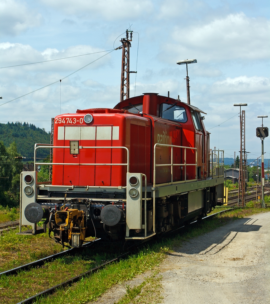 Die 294 743-0 (V90 remotorisiert), ex DB 290 243-5, der der DB Schenker Rail am 10.07.2013, bei der Arbeit am Ablaufberg in Kreuztal.

Die V90 wurde 1971 bei MaK in Kiel unter der Fabriknummer 1000551 gebaut und als 290 243-5 an die DB geliefert und wurde 1994 in 290 243-1 um bezeichnet. 1997 erfolgte der Umbau mit Funkfernsteuerung und die Umzeichnung in 294 243-1.

Die Remotorisierung mit einem MTU-Motor 8V 4000 R41, Einbau  einer neuen L�fteranlage, neuer Luftpresser und Ausr�stung mit dem Umlaufgel�nder erfolgten 2004 bei der DB Fahrzeuginstandhaltung GmbH im Werk Cottbus. Daraufhin erfolgte die Umzeichnung in 294 743-0. 
Die kompl. NVR-Nummer 98 80 3294 743-0 D-DB bekam sie dann 2007.

Die Baureihe 290 wurde f�r den schweren Rangierdienst, sowie f�r Bedien- und �bergabefahrten konzipiert. Die Lok ist eine Weiterentwicklung aus den Streckenlokomotiven der Baureihenfamilie V100 (BR 211 und BR 212) der Deutschen Bundesbahn. Die V90 ist gegen�ber der V100 deutlich schwerer und robuster im Rangierdienst. Urspr�nglich war geplant, f�r den schweren Rangierdienst eine ballastierte Variante der V 100 mit verst�rktem Rahmen zu beschaffen, die Fahrzeugauslegung war daf�r aber nicht geeignet (die Achslast lie� sich so nicht auf die geforderten 20 t erh�hen). 

Nachdem ab dem Jahr 1964 die Vorserienmaschinen (20 St�ck) mit dem kleineren Motor der BR 211 von Mak ausgeliefert wurden, begann ab 1966 die Auslieferung der ersten Serienmaschinen. Unterschied zu den Vorserienloks ist der etwas st�rkere (gedrosselte) MTU MB 12 V 652 TZ (TA) 10 Motor (809 kW/1100 PS) der BR 212 und der damit um 10 km/h auf 80 km/h heraufgesetzten H�chstgeschwindigkeit. Insgesamt wurden 408 Loks ausgeliefert.
Die remotorisiert Maschinen haben nun einen MTU DM 8V 4000 R41 Motor mit 1000 kW/1360 PS Leistung bei 1800 U/min, sie erf�llen die Abgasnorm UIC Kodex 624V, Stufe II.

Technische Daten:

Achsanordnung: B'B'
Spurweite: 1.435 mm
L�nge �ber Puffer: 14.320 mm
Breite: 3.100 mm
Drehzapfenabstand: 7.000 mm
Gesamtachsstand: 9.500 mm
H�chstgeschwindigkeit: 80 km/h Streckengang / 40 km/h Rangiergang 
kleinste Dauergeschwindigkeit: 9 km/h Streckengang / 3 km/h Rangiergang

Motorhauptdaten (Quelle: MTU):
Motorbauart: MTU 8-Zylinder-Diesel-V-Motor 90� mit Common-Rail-Einspritzsystem, Abgas-Turbolader und Ladeluftk�hlung
Motortyp:   8V 4000 R41 
Nennleistung:  1000 kW / 1341 PS (gedrosselt)
Drehzahl max.:  1800  1/min   
Bohrung/Hub: 165/190 mm
Hubraum: 32,5l
Kraftstoffverbrauch bei Nennleistung: 249,4 l/h
Abgas-Emission :   UIC Kodex 624V, Stufe II
L�nge: 1.915 mm
Breite: 1.380 mm
H�he: 1.800 mm
Gewicht (trocken): 4.700 kg

Getriebe und Leistungs�bertragung:
Das hydraulische Getriebe von Voith hat zwei Wandlerg�nge. Ein mechanisches Nachschaltgetriebe erm�glicht die Wahl zwischen einem Schnell- und einem Langsamgang sowie den Wechsel der Fahrtrichtung. Um feinf�hlige Langsamfahrten zu erm�glichen, hat das Getriebe eine stufenlos regelbare Wandlerteilf�llung.
Die Leistungs�bertragung auf die Achsgetriebe erfolgt dann �ber Gelenkwellen.