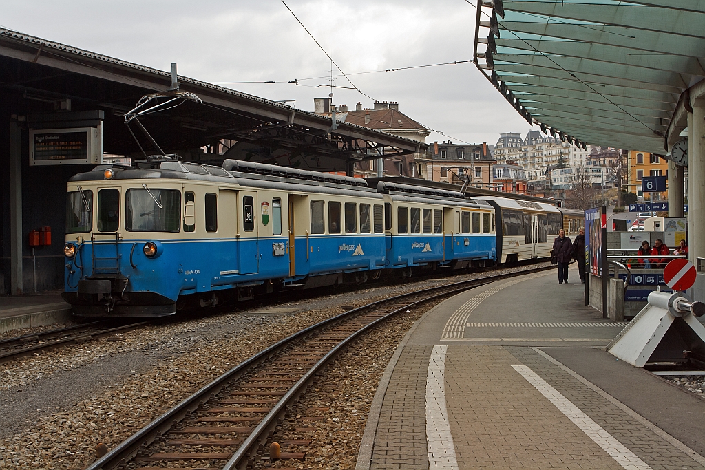 
Doppeltriebwagen ABDe 8/8 Nummer 4002 (Vaud) der Montreux–Berner Oberland-Bahn (MOB), französisch Chemin de fer Montreux-Oberland bernois, am 26.02.2012 im Bahnhof Montreux. 

Der 1.000 mm spurige Triebwagen wurde 1968 gebaut, die Achsformel ist Bo'Bo' + Bo'Bo', die Höchstgeschwindigkeit ist 70 km/h. Er steht hier, mit angehängten Wagen, zur Abfahrt bereit nach Zweisimmen, diese Strecke hat eine Maximalsteigung von 73 ‰ (und das ohne Zahnstange).

