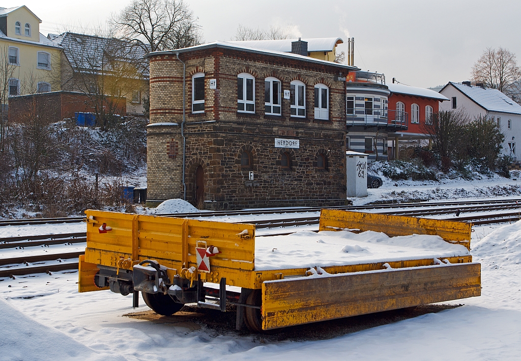 Gegen�ber dem 1901 gebautem Stellwerk Herdorf Fahrdienstleiter (Hf) ist am 17.01.2013 dieser Gleiskraftwagenanh�nger Kla 01 (Kleinwagen-Nr. 01 0769-5) der Fa. A. M�hlbauer Bau aus M�nchen abgestellt (neben dem Gleis). 
Der Wagen ist Baujahr 1961, hat ein Eigengewicht von 3,0 t und eine Nutzlast von 5,0 t, die Gesamtl�nge betr�gt 2.500 mm.