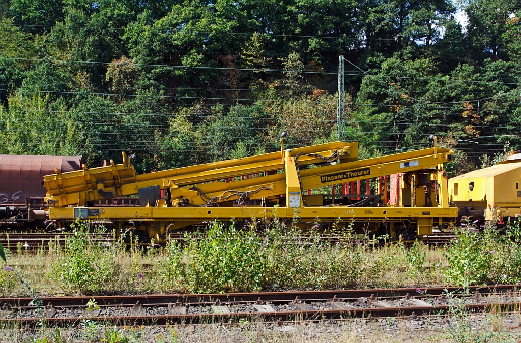 
Plasser & Theurer Beladestation BLS 2000 (Schweres Nebenfahrzeug Nr. 97 19 26 502 57-8) der Hering Bau, Burbach, abgestellt am 25.08.2012 in Betzdorf/Sieg.
Um Schüttgüter mittels Erdbaugeräten (Bagger etc.) in MFS-Einheiten fördern zu können, ist die Beladestation entwickelt worden. Sie besteht aus 
Schottertrichter, breitem Kettenförderband und hydraulisch ein- und ausfahrbarem Übergabeförderband mit Schwenkeinrichtung für die 
Arbeit im Gleisbogen. Die BLS 2000 ist ein zweiachsiges, gleisfahrbares Gerät. Zur leichten Beladung kann der Schottertrichter während 
der Arbeit hydraulisch abgesenkt werden. 

Technische Daten:
Achsanzahl: 2
Eigengewicht:  22.300 kg
Länge über Puffer: 12.900 mm
Achsabstand: 8.000 mm
Höchstgeschwindigkeit: 100 km

