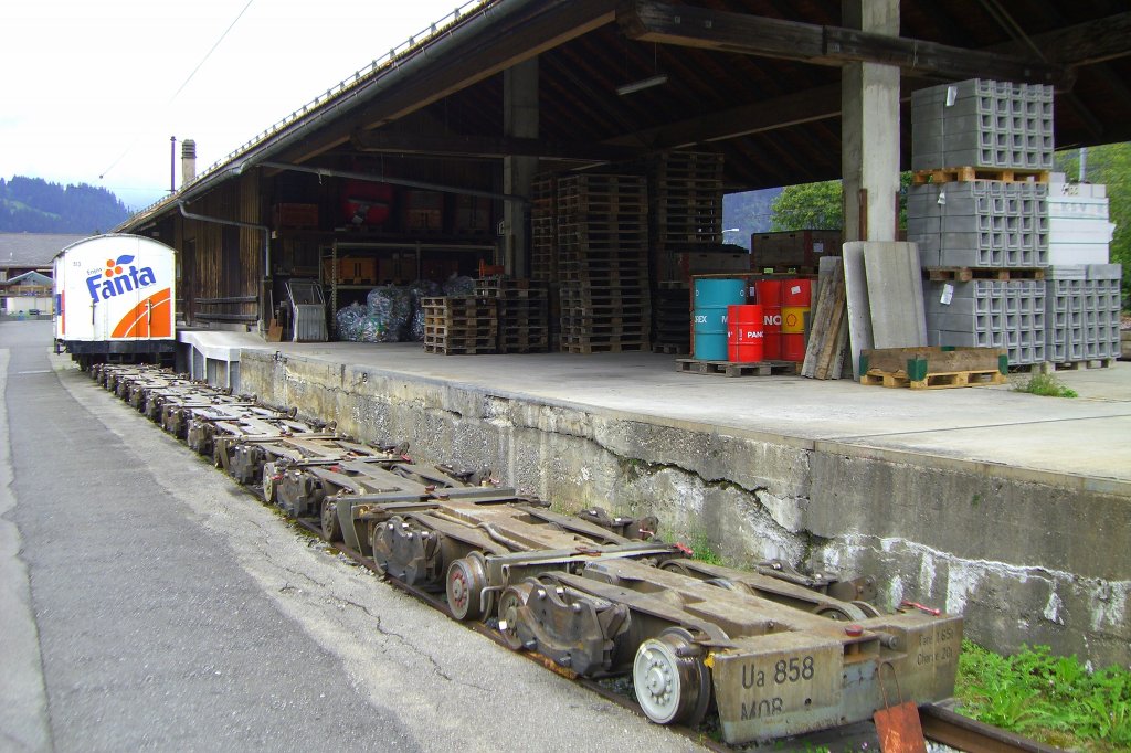 Rollbock Ua 858 der MOB im Bahnhof Zweisimmen am Ladegleis mit einigen weiteren Vertretern seiner Gattung vor einem G-Wagen mit Fanta-Werbung. (03.08.2007).