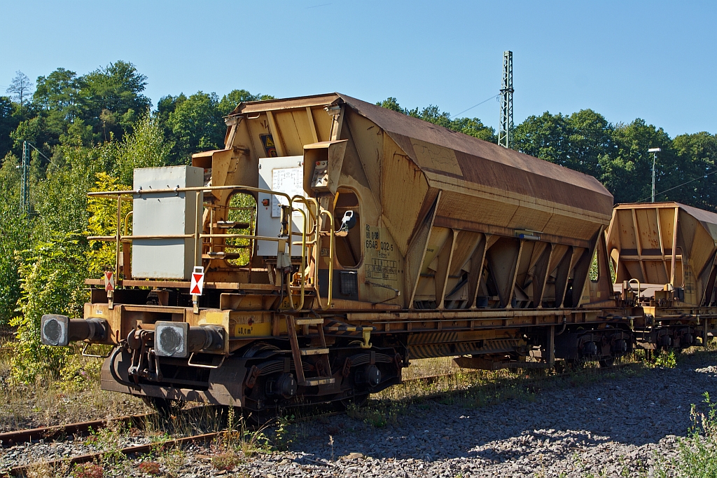 Schotter-Kieswagen Facns 141 (82 80 6648 002-5), abgestellt am 08.09.2012 in Betzdorf/Sieg mit 7 weiteren Wagen. 
Die Entladung erfolgt �ber zwei Schwingf�rderrinnen und ein ausschwenkbares F�rderband wahlweise nach beiden Wagenseiten. Der Abwurfbereich liegt zwischen 2 m und 4,1 m zur Fahrzeugl�ngsachse. Die Entladzeit einschlie�lich R�stzeit betr�gt 8 Minuten. Die 40 m� Ladegut k�nnen in dieser kurzen Zeit aus geringer Fallh�he in die Baugruppe entleert werden und bei langsamer Geschwindigkeit durch schwenken des F�rderbandes auch verteilt werden. 