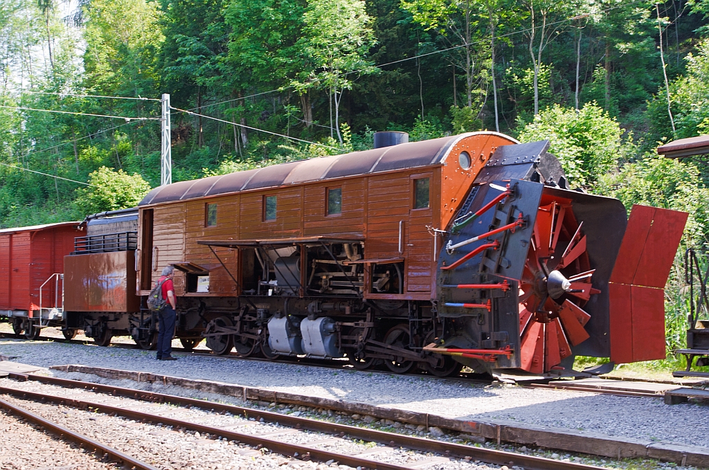 Selbstfahrende Dampfschneeschleuder R 1052 (ex Berninabahn R 1052, ex RhB R 14, ex RhB  Xrot d 9214), der Museumsbahn Blonay-Chamby,hier am 27.05.2012 auf dem Museums-Areal der (BC) in Chaulin.

Die Schneeschleuder wurde 1912 von der Schweizerischen Lokomotiv- und Maschinenfabrik (SLM) als R 1052 f�r die Berninabahn gebaut,  1944 umbezeichnet in RhB R 14, 1954 umnummeriert in Xrot d 9214 (Die Bezeichnung Xrot d setzt sich zusammen aus: X = Dienstfahrzeug, rot = rotierend, d = dampfgetrieben.) , 1990 an DFB, 1996 von der DFB im Tausch gegen die ehemalige RhB R 12 �bernommen. 

Dieses Fahrzeug wie auch das heute noch bei der RhB betriebsf�hige Schwesterfahrzeug  Xrot d  9213 (ex BB R 1051) sind dampfgetriebene Schneeschleudern mit eigenem Antrieb die f�r die Berninabahn (BB) gebaut wurden, die seit 1944 zur Rh�tischen Bahn geh�rt. Im Gegensatz zu den bisher gebauten Fahrzeugen, auch der zwei Dampfschleudern der RhB-Stammstrecke, handelt es sich bei den beiden Bernina-Schleudern um selbstfahrende Fahrzeuge. Die Berninabahn entschied sich hierzu, weil in den engen Kurven nicht mit gen�gend hoher Kraft geschoben werden konnte und die Bahn selbst keine Fahrdraht-unabh�ngigen Triebfahrzeuge besa�. Die Schleudern wurden dennoch normalerweise mit Schiebetriebfahrzeugen eingesetzt, damit die gesamte Kesselleistung f�r die Dampfmaschine des Schleuderrades zur Verf�gung stand.

Die Achsformel ist C'C', das Fahrzeug verf�gen nach Bauart Meyer �ber zwei dreiachsige Triebdrehgestelle die durch vier Zylinder angetrieben werden, diese befinden sich unten mittig zwischen den Triebgestellen, dar�ber befindet sich der Antrieb f�r die Schneeschleuder, die von zwei weiteren Zylindern angetrieben wird. Der Durchmesser des Schleuderrads betr�gt 2,5m, welches mit bis zu 170 Upm dreht und so bis zu drei Meter hohe Schneemassen beseitigen kann.
Gekuppelt ist die Schneeschleuder mit einem zweiachsigen Tender.
