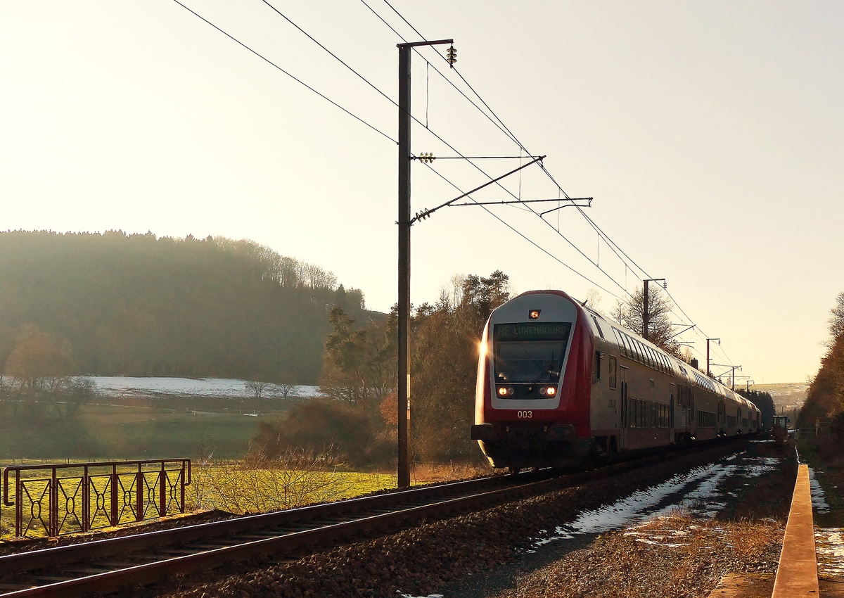 . Der Schnee ist (fast) weg, jetzt muss es die Abendsonne richten - Steuerwagen voraus f�hrt der RE 3841 Troisvierges - Luxembourg im abendlichen Gegenlicht des 11.02.2015 �ber den eingleisigen Abschnitt der Nordstrecke zwischen Cinqfontaines und Maulusm�hle. Schublok war die 4018. (Jeanny) 