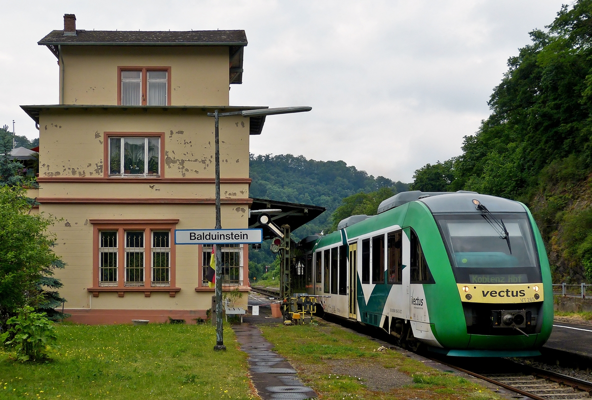 . Der Vecuts VT 265 verl�sst am 26.05.2014 den Bahnhof von Balduinstein, um seine Fahrt nach Koblenz Hbf fortzusetzen. (Hans)

Das sp�tklassizistische Bahnhofsgeb�ude entstand nach Pl�nen des Diezer Architekten Heinrich Velde, der auch zahlreiche weitere Bauten entlang der Bahnstrecke entwarf. Der zweigeschossige Bau wurde mit dreigeschossigen Eckbauten und laubenartiger Vorhalle sehr gro�z�gig ausgef�hrt. Am 9. September 1991 wurde das Bahnhofsgeb�ude in die Denkmalliste des Landes Rheinland-Pfalz aufgenommen.