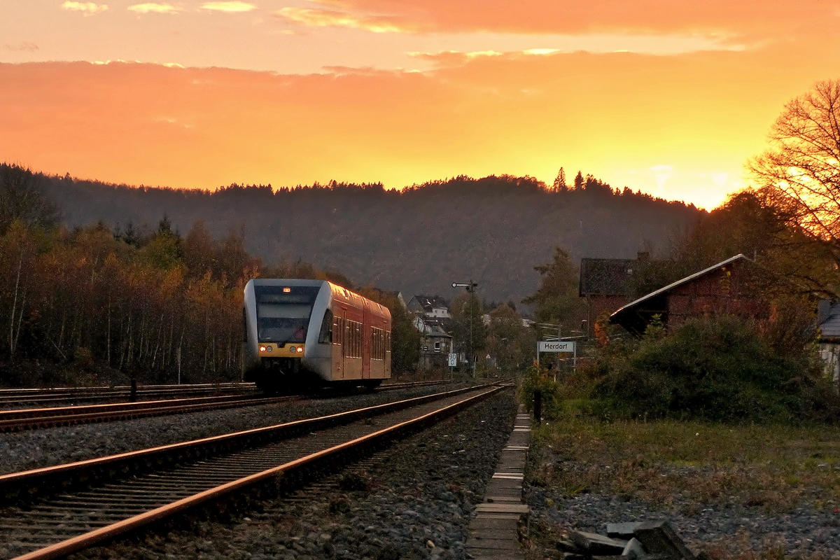 . Sonnenuntergang in Herdorf - W�hrend die Sonne sich am 01.11.2014 sehr eindrucksvoll verabschiedet, verl�sst ein Stadler GTW 2/6 der Hellertalbahn den Bahnhof von Herdorf. (Jeanny)