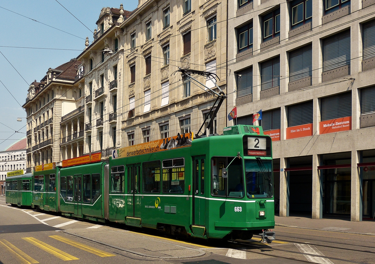 . Vor dem Bahnhof Basel SBB konnte ich am 07.06.2015 die BVB Tram Be 4/6 S N� 663 ablichten, als sie auf der Linie 2 durch die Centralbahnstrasse fuhr. Wegen des Pokalspiels Basel - Sion, waren alle Basler Stra�enbahnen mit den Flaggen des FC Basel geschm�ckt. (Hans)


Bei diesem Fahrzeugtyp handelt es sich um die urspr�nglichen Be 4/6, welche 1997-1999 mit niederflurigen Mittelteilen (sogenannten S�nften) erweitert wurden. Sie wurden 1990-1991 von Schindler in der Anzahl von 28 St�ck gebaut und werden als Guggummere bezeichnet.
