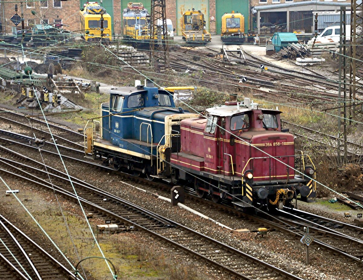 364 858-1 und 365 143-7 in Doppeltraktion in Ulm am 14.12.2013. Die 364 wird manuell bedient, während die 365 im Funk gesteuert wird (am seitlichen Licht am Führerstand zu erkennen).
Im Hintergrund sind diverse Bahndienstfahrzeuge zu erkennen. 