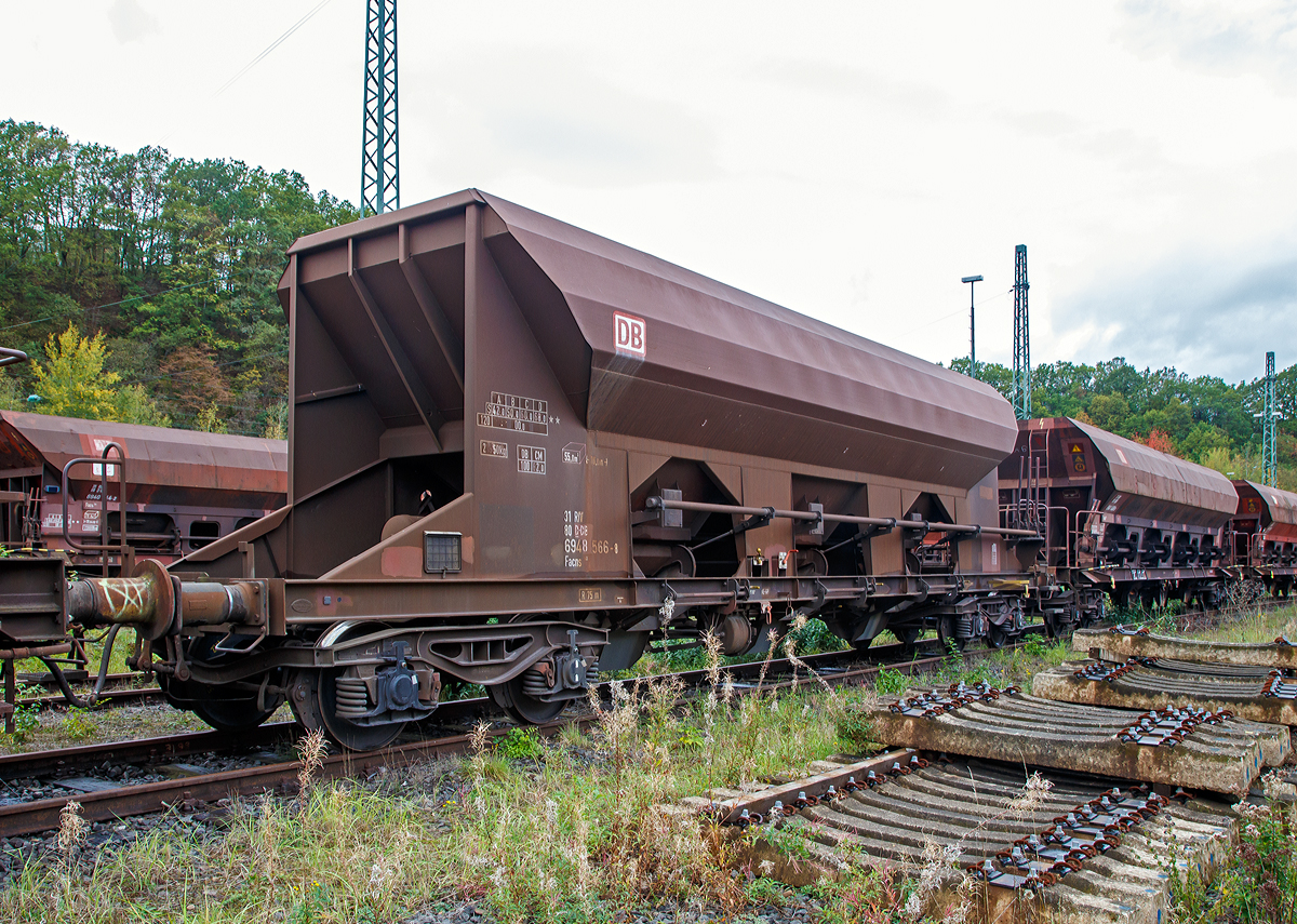 
4-achsigiger offener Drehgestell-Schüttgutwagen mit dosierbarer Schwerkraftentladung der DB Cargo AG, 31 80 6948 566-8 d-DB, der Gattung Facns 133, abgestellt am 19.10.2019 in Betzdorf (Sieg).

Der Wagen wurde 1996 unter der Fabriknummer 2555 von Linke-Hofmann-Busch GmbH (LHB) in Salzgitter-Watenstedt gebaut. 

Da bleibt nichts übrig: Bei den offenen Selbstentladewagen hat der Laderaum die Form drei nebeneinander stehender Trichter. Der Entladevorgang erfolgt über die Schwerkraft des Ladegutes. Jeweils drei Auslauföffnungen mit Drehschiebern je Längsseite ermöglichen die restlose Entladung des Wagens nach der einen oder anderen Seite. Die Menge ist regulierbar - so wie es zum Beispiel beim Einschottern oder für die Entladung über Förderband erforderlich ist. Geeignet sind die Wagen für den Transport nicht nässeempfindlicher Güter in loser Schüttung. Die Drehschieber über einer Einrichtung auf der Bühne an einer Stirnseite des Wagens können einzeln bedient werden.

Der Wagen eignet sich für die Beförderung von Schüttgütern aller Art, die nicht nässeempfindlich sind. Die regelbare Entladung ermöglicht die Beschickung von Förderbändern. Die schwenkbaren Auslaufrutschen gestatten den Einsatz des Wagens für Bunkerentladung. Gegenüber Fc-Wagen früherer Bauarten ist das Ladevolumen auf die Tragfähigkeit für speziell schwere Ladegüter (Baustoffe) abgestimmt.
Für die Kastenbleche wurde Chromstahl 1.4003 verwendet.
In jeder Seitenwand sind drei Rundschieber angeordnet. Die Schieber werden mit Handhebeln geöffnet und geschlossen. Durch eine Klinkensperre können Schieberöffnungen bis zu 160 mm in Abstufungen von 20 mm und außerdem die volle Schieberöffnung von 380 mm eingestellt werden. Es sind insgesamt 8 Schieberstellungen möglich.

TECHNISCHE DATEN:
Hersteller: Linke-Hofmann-Busch GmbH (LHB), heute Alstom
Spurweite: 1.435 mm (Nornalspur)
Achsanzahl: 4 in zwei Drehgestellen
Länge über Puffer: 16.000 mm
Drehzapfenabstand: 10.960 mm
Achsabstand im Drehgestell: 1.800 mm
Drehgestell-Bauart: Y 25 Lsd 1 - 628
Laderaum: 55 m³
Höchstgeschwindigkeit: 100 km/h (beladen) / 120 km/h (leer)
Maximales Ladegewicht: 68 t (ab Streckenklasse D)
Eigengewicht: 21.950 kg
Kleinster bef. Gleisbogenradius: R 75 m
Verwendungsfähigkeit: RIV
