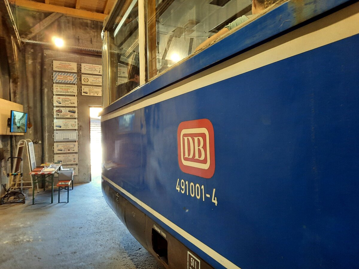 491 001-4 Gläserner Zug im Bahnpark Augsburg am 26.06.2022. Seitenansicht, am Eingang Schildersammlung von Zielen des Gläsernen Zugs.