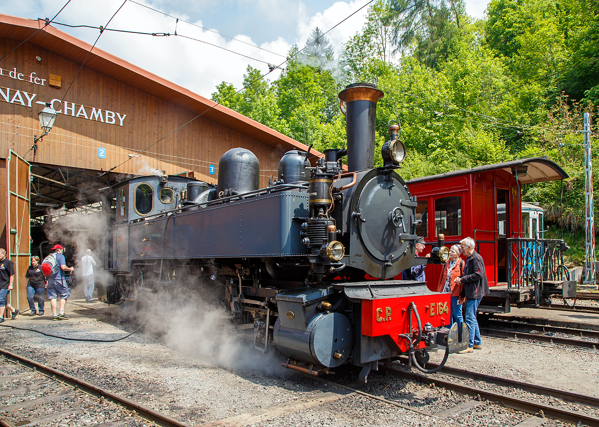 
50 Jahre BC - MEGA STEAM FESTIVAL der Museumsbahn Blonay–Chamby: 
Eine wahre Schöhnheit......
Die G 2x2/2 Mallet-Dampflokomotive ex C.P. E164, ex MD 404, vom Verein La Traction als Gastlok beim Mega Steam Festival der BC, hier am 19.05.2018 beim Depot in Chaulin.

Mallet-Dampflok wurde 1905 von Henschel in Kassel (damals noch Cassel) unter der Fabriknummer 7022 gebaut. Sie gehörte zu einer Serie von zehn Maschinen, die zwischen 1905 und 1908 von Henschel an die damalige Minho e Douro Bahn in Portugal geliefert wurde. Nach der Verstaatlichung im Jahre 1947 erhielt sie die Nummer C.P.  E168, so war sie bis 1978  im Einsatz. Der Verein La Traction hat sie1992 von der Caminhos de Ferro da Portugal (CP) gekauft. 1998 erhielt La Traction von der Fondation d'Impulsion économique régionale (FIER) einen Beitrag, um diese Lokomotive zu revidieren. Nach einer durchgreifenden Aufarbeitung durch das Dampflokwerk Meiningen in Deutschland kam diese Lokomotive im Sommer 1999 wieder in die Schweiz zurück. Sie wurde am 19. September desselben Jahrs eingeweiht. 
Es sei noch erwähnt, das Niederdruckfahrwerk stammt von der Lokomotive E 169, die heute in Vila Real aufgestellt ist.

Eine Schwesterlok die ex CP 168 ist in Brohl (Deutschland) siehe http://hellertal.startbilder.de/bild/Deutschland~Schmalspurbahnen~Brohltalbahn/433231/leider-ein-tristes-dasein-aber-ziel.html


TECHNISCHE DATEN:
Spurweite: 1.000 mm
Achsfolge: 	(B) B 
Länge über Kupplungen: 10.850 mm
Größte Höhe: 3.750 mm
Größte Breite: 2.700 mm
Gesamtachsstand: 5.200 mm
Triebraddurchmesser: 1.100 mm
Leergewicht: 34,5 t
Dienstgewicht: 42,0 t
Kohlenvorrat: 1,5 t
Wasservorrat: 5,5 m³
HD Zylinder: 2 x Ø 320 mm x 550 mm Hub
ND Zylinder: 2 x Ø 480 mm x 550 mm Hub	
Kesseldruck: 14 bar
Rostfläche: 1,33 m²
Höchstgeschwindigkeit: 40 km/h


Geschichte der Mallet-Lokomotiven:
Der zunehmende Verkehr auf schmalspurigen Eisenbahnen erschloss Mallet ein anderes Wirkungsfeld. Diese Bahnen benötigten stärkere und damit größere Maschinen, als es die engen Kurven der Schmalspurstrecken zuließen. Die einzige Lösung schienen hier Lokomotiven mit schwenkbaren Fahrwerken zu sein. Dazu waren bereits die Bauarten von Fairlie und Meyer verbreitet, die schwenkbare Maschineneinheiten verwendeten. Die einzelnen Einheiten wurden mit Dampf über flexible Verbindungen gespeist, die sich jedoch stets als Schwachpunkt der Maschinen erwiesen. Mallet entwickelte stattdessen eine Bauart mit zwei Fahrwerken, von denen nur das vordere, unter der Rauchkammer befindliche Fahrwerk schwenkbar gelagert war, während der Kessel fest auf dem anderen Fahrwerk ruhte. Damit reduzierte sich die Zahl der flexiblen Verbindungen um die Hälfte. Der wesentliche Unterschied der Konstruktion von Mallet im Vergleich zu den Bauarten Fairlie und Meyer war aber die perfekte Anwendung eines Verbundtriebwerkes. Der Frischdampf wird zunächst zu den Hochdruckzylindern des fest gelagerten Fahrwerks geleitet und nach dem Auslass in die Niederdruckzylinder des vorderen beweglichen Fahrwerks. Die dorthin führende bewegliche Dampfleitungsverbindung war wegen des geringeren Drucks besser beherrschbar als bei reiner Frischdampf-Versorgung. Diese Bauart ließ Mallet sich 1884 patentieren. 

Dampflokomotiven haben im Allgemeinen zwei Arbeitszylinder, die Mallet-Loks besitzen diese Einrichtungen doppelt, also 4 Zylinder mit zugehörigen Triebwerksgruppen. Der Abdampf der ersten ist gleichzeitig der Arbeitsdampf der zweiten Zylindergruppe.
