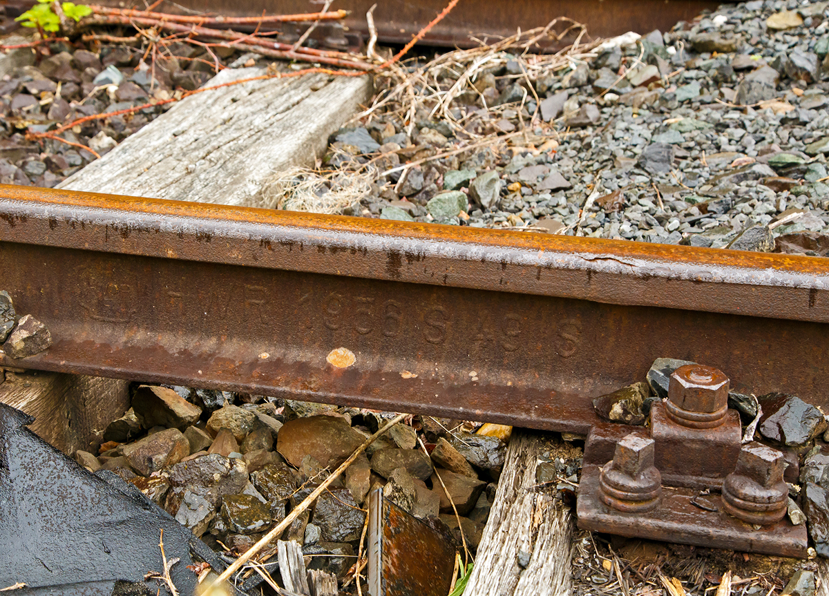 
Altes Schienen-Walzzeichen, fotografiert am 24.05.2020 im dem stillgelten Bereich des Rbf. Betzdorf (Sieg).

Anhand des Walzzeichens sieht man:
Den Hersteller:
HWR = Hütten- und Bergwerke Rheinhausen AG, es war eine Gesellschaft innerhalb des kruppschen Firmenimperiums. Am 3. Dezember 1982 gab die Krupp Stahl AG die Schließung ihres Walzwerks in Duisburg-Rheinhausen bekannt. 1987 erhielt Rheinhausen durch den Widerstand gegen die Schließung des damals vorhandenen Stahlwerks große Medienpräsenz.

Das Herstellungsjahr: 1958

Das Schienenprofil (und das ungefähre Metergewicht): 
S 49 Schiene 49,43 kg/m, Höhe 149mm, Fußbreite 125 mm, Schienenkopfbreite 67 mm, Stegstärke 14 mm, Wiederstandsmoment (Wx) 240 cm³

Das Stahl-Herstellungsverfahren: S = Siemens-Martin-Stahl
Ein Kennzeichen für die genaue Stahlqualität gibt es nach den alten Walzzeichen nicht.
