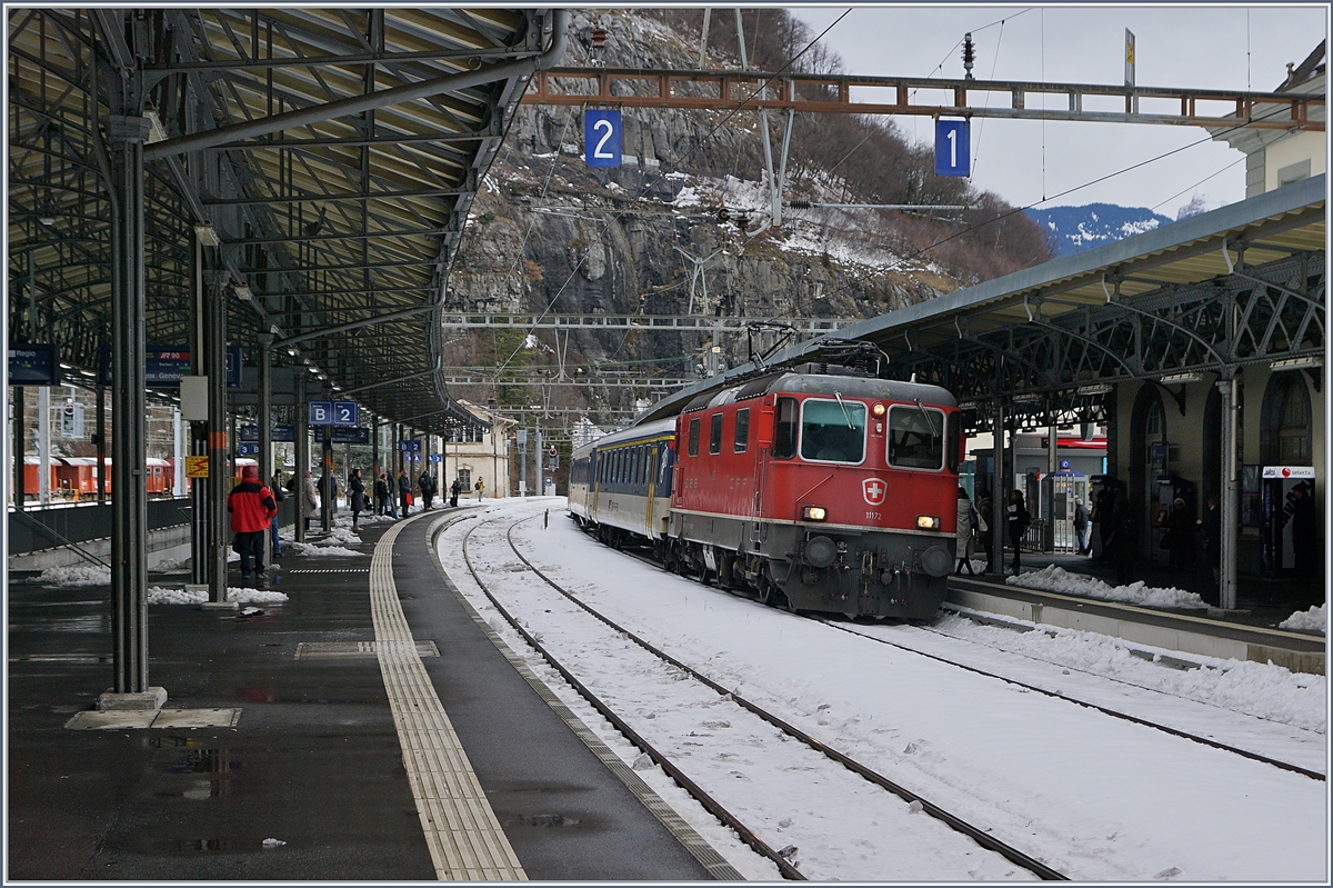 Am Nachmittag und Abend des 10. Dez. fiel im Chablais so viel Schnee, dass eine Re 460 mit ihrem IR bei Bex in einer Schneeverwehung stecken blieb. Da es im 15 Kilomomter weiter entfernten Blonay kaum Schnee hatte, wollte ich am folgenden Tage die Sache bzw. den Schnee im Tal unten mal anschauen, und war dann doch überrascht, dass der Meter hohe Schnee durch den starken Föhn bereits grösstenteils weggeschmolzen war und ich bis St-Maurice fahren musste, um einen wagen Eindruck des hereingebrochenen Winters zu erhaschen.
Das Bild zeigt die SBB Re 4/4 11172 die mit einem IR (in geänderter Formation/Disopzug) von Lausanne kommend in St-Maurice eintrifft.
11. Dez. 2017