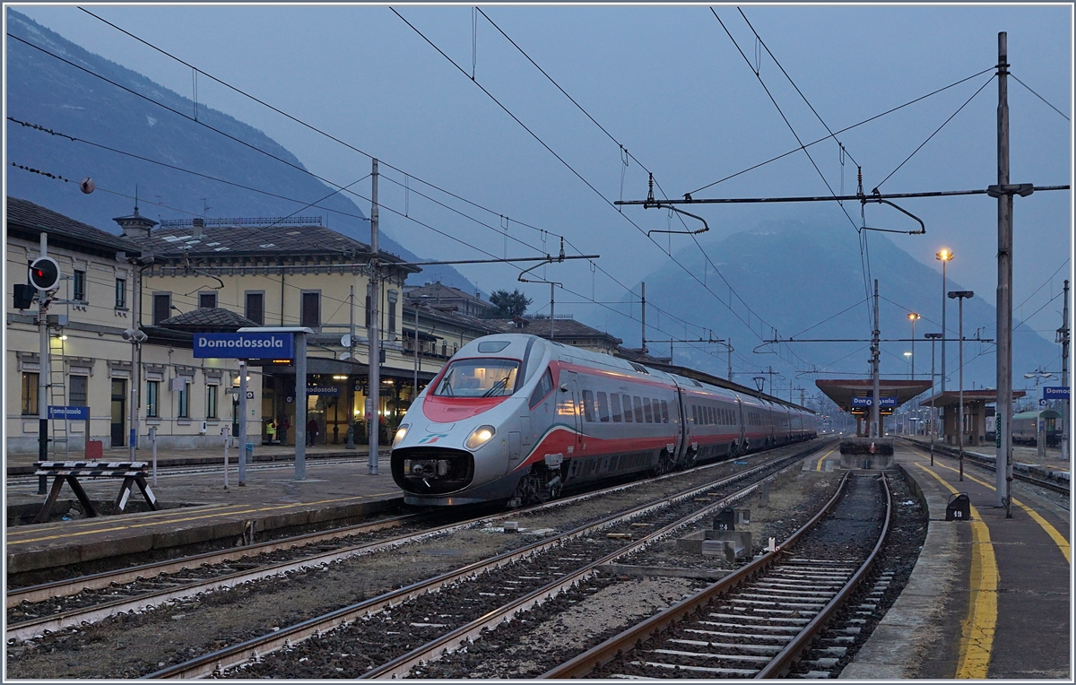 An einem noch dämmrigen Januar Morgen wartet ein FS Trenitalia ETR 610 in Domodossola auf die Weiterfahrt nach Milano. 
Der Zug verkehrt als EC 35 von Genève nach Milano Centrale.

16. Jan. 2018
