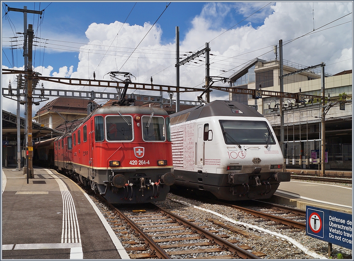 An der Lok und deren Anschriften vorbeigeschlendert und gerechnet: die 1975 gebaute Re 4/4 II 11264 ist ja schon 45 Jahre alt... Die beiden Re 4/4 II 11264 und 11296 warten in Lausanne die Blockdistanz zum IR 90 ab, um ihre Fahrt nach Domo II fortsetzen zu können. 

Rechts im Bild ist die SBB Re 460 113  100 Jahren SEV  die mit ihrem IR15 Luzern Genève - Lausanne verlässt. 

18. Juni 2020