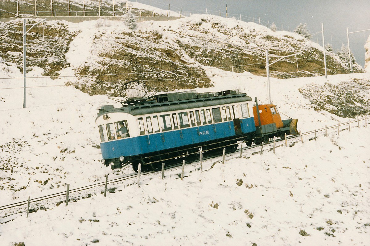 ARB: BDhe 2/3 6 (1911) noch im blauen Kleid mit Schneepflug zwischen Rigi Kulm und Rigi Staffel im November 1985. F�r das F�hrerhaus des Schneepfluges wurde die Kabine eines alten Mercedes Lieferwagen zweckentfremdet. Zu dieser Zeit befand sich der Triebwagen in einem sehr schlechten Zustand. Aus diesem Grunde war er nur noch selten auf der Strecke unterwegs. Auch eine Total-Revision war damals noch keine beschlossene Sache.
Foto: Walter Ruetsch 