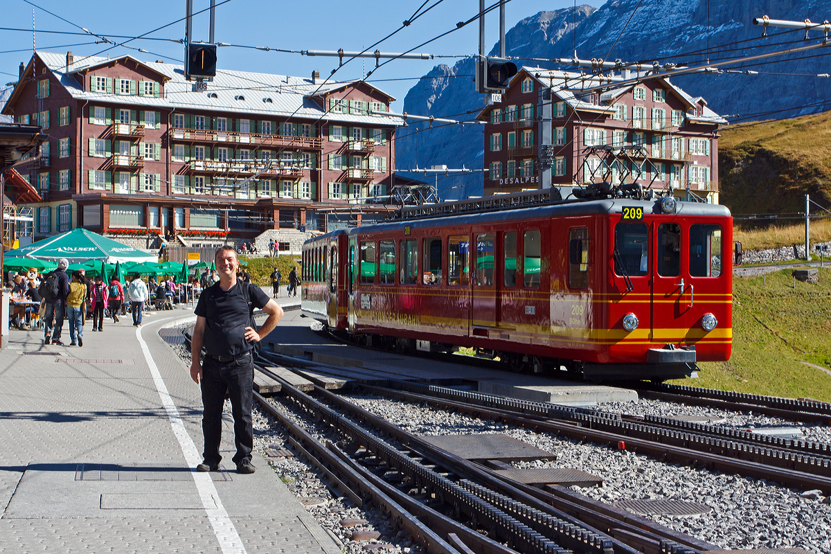 
Bei Kaiserwetter beim Bahnhof Kleine Scheideeg am 02.10.2011, links unser Webmaster Baujahr 1963 und rechts steht der ein Jahr j�ngere Triebzug der Jungfraubahn, bestehend aus dem BDhe 2/4 Triebwagen Nr. 209 und dem Steuerwagen Bt 33. 
Im Hintergrund das Hotel Bellevue des Alpes.
