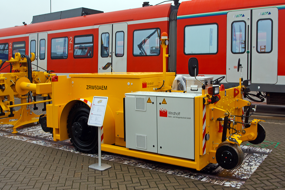 
Das Zwei-Wege-Rangierfahrzeuge Windhoff ZRW 50 AEM (Akku-Elektrischem Antrieb) hier am 26.09.2014 präsentiert auf der Inno Trans 2014 in Berlin.

Die Windhoff Zwei-Wege-Rangierfahrzeuge (ZRW) werden seit dem Jahr 1993 hergestellt. Sie wurden speziell für innerbetriebliche Rangieranwendungen für Werkstätten, Industrie, Werk- und Hafenbahnen entwickelt. Ferner können sie für Rangieraufgaben im Zusammenhang mit Unterflurdrehbänken (UFD) oder Waschanlagen benutzt werden. Die ZRW sind als emissionsfreie Akkufahrzeuge (AEM), Dieselfahrzeuge (DH) oder Akku/Diesel-Hybrid (DAE) lieferbar.

Die neue Modellreihe versteht sich als technische Weiterentwicklung der bewährten ZRW Vorgängermodelle. Die Auslegung der Windhoff Fahrzeuge orientiert sich an robusten Schienenfahrzeugen, nicht an umgebauten Straßenfahrzeugen. Eisenbahnspezifische Anforderungen an Dauerfestigkeit, Rahmenstabilität (z.B. Pufferstoß), Kuppelsysteme, Spurführung, Kompressoranlage, Funksysteme, Entgleisungssicherheit usw. wurden bei der Entwicklung berücksichtigt.

Technische Daten ZRW 50 AEM:
Spurweiten: 1.435 mm (1.000 mm bis 1.600 mm lieferbar)
Zugkraft: 50 kN (bei Nässe 34 kN)
Anhängelast: bis 1.000 t 
Dienstgewicht: 12.000 kg
Länge:.2.000mm / Breite: 1.900 mm / Höhe: 2.000 mm
Geschwindigkeit: stufenlos regelbar  0 bis 8 km/h
Antriebsmotor: drehzahlgeregelter AC-Motor
Leistung: 35 kW (Nenn) bzw. 70 kW (Spitzenleistung)
Batterie: 80 V / 1000 Ah
Optional ist auch eine Funkfernsteuerung lieferbar

