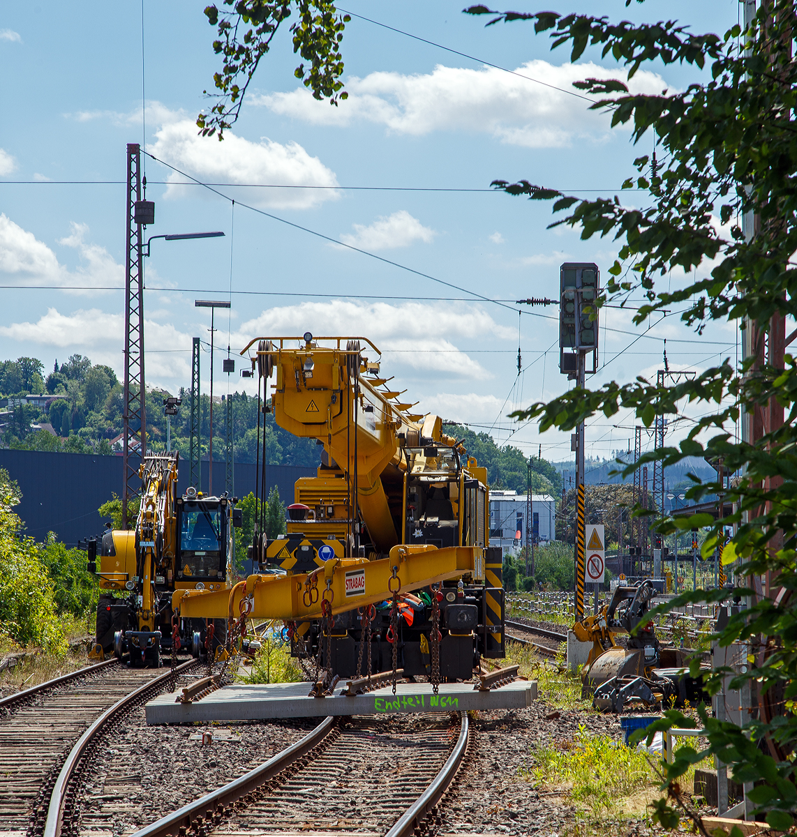 Der 50 t GOTTWALD Gleisbauschienenkran GS 50.09 T, Schweres Nebenfahrzeug Nr. 99 50 9219 028-9 CH-BRS „Werner“ der BMTI Rail Service GmbH (Servicebetrieb der STRABAG SE), ex VTmaas 99 85 92 19 028-9 VANOMAG AG Kran VIII, ex VTmaas 80 85 94 81 407-7, ist am 30.07.2021 im Bahnhof Siegen-Weidenau im Einsatz. Nun ist aber erst mal Mittagspause.

Der Kran wurde 2002 von Gottwald in Düsseldorf gebaut.

TECHNISCHE DATEN:
Spurweite: 1.435 mm
Anzahl der Achsen: 6 (in 2 Drehgestellen)
Länger über Puffer: 12.000 mm (ohne Kranausleger)
Drehzapfenabstand: 7.000 mm
Achsabstand im Drehgestell : 1.500 mm
Raddurchmesser: 920 mm (neu) 
Breite in Transportstellung: 3.100 mm
Höhe in Transportstellung: 4.200 mm
Eigengewicht: 116 t in Transportstellung (Gegengewicht abgelegt)
Traglast:  50.000 kg bei 3,0 m Ausladung vor Puffer 
  18.300 kg bei 12,5 m Ausladung vor Puffer
Kleinster befahrbarer Radius: 90 m 
max. Geschwindigkeit im Zugverband: 100 km/h
max. Geschwindigkeit im Eigenantrieb: 25 km/h
Bremse: KE-GP mZ (D)
