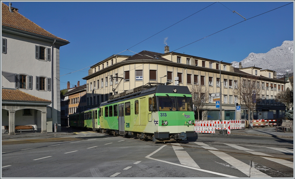 Der A-L BDeh 4/4 313 verlässt mit seinem Zug die Altstadt von Aigle. Der Zug ist von Aigles nach Leysin unterwegs und erreicht unmittelbar nach der Überquerung der Kreuzung die Haltestelle Aigle-Place-du Marché. Wie auf dem Bild rechts oben zu erkennen ist, hat es in den Bergen geschneit, weshalb bei diesem schönen Sonntagswetter der Zug neben dem BDe 4/4 313 zwei Wagen mitführt.

3. Dezember 2023