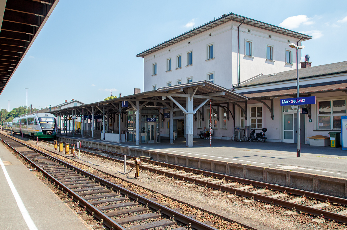 
Der Bahnhof Marktredwitz am 01.07.2015, der Bahnhof der Großen Kreisstadt Marktredwitz im bayerischen Regierungsbezirk Oberfranken. Dort kreuzen sich die beiden Hauptstrecken Nürnberg–Cheb und Regensburg–Hof.

Der Marktredwitzer Bahnhof – bei der Eröffnung noch als Bahnhof Markt Redwitz bezeichnet – ist ein wichtiger Eisenbahnknotenpunkt in Nordbayern. Er befindet sich im nordwestlichen Stadtgebiet und ist von der Innenstadt etwa fünf Gehminuten entfernt.

Der Bahnhof wurde am 15. Mai 1878 von der Bayerischen Staatsbahn zusammen mit den Bahnstrecken Schnabelwaid – Marktredwitz (heute Teilstück der Strecke Nürnberg – Cheb) und Marktredwitz – Holenbrunn (heute Teilstück der Strecke Regensburg – Hof) als Durchgangsbahnhof eröffnet. Der Ausbau zum Kreuzungsbahnhof fand mit der Inbetriebnahme des Abzweigs nach Schirnding am 20. November 1879 (später bis Cheb (Eger) verlängert, beides heute Teilstücke der Strecke Nürnberg – Cheb) und der Verbindung nach Wiesau (heute Teilstück der Strecke Regensburg – Hof) am 1. Juni 1882 statt.

Vor dem Zweiten Weltkrieg war Marktredwitz ein wichtiger Eisenbahnknotenpunkt für ganz Europa. An ihm kreuzten sich die Linien Rom – München – Berlin – Stockholm und Paris – Nürnberg – Prag. Täglich verließen über hundert Züge den Bahnhof in alle vier Himmelsrichtungen. Auch beim Fall der Mauer spielte der Marktredwitzer Bahnhof eine entscheidende Rolle. Für viele DDR-Bürger war es die erste Gelegenheit, die überfüllten Züge zu verlassen, die über Hof die Grenze passierten, oder direkt von Eger kommend, am Bahnhof Halt machten.

Bis 2006 war Marktredwitz Haltepunkt der InterCity-Verbindung Nürnberg – Hof – Dresden, seit deren Einstellung wurde Marktredwitz vom Franken-Sachsen-Express (FSX) bedient, der im Regionalverkehr die frühere IC-Linie ersetzt hat. Nach der Elektrifizierung der Strecke Reichenbach – Hof wurde auch diese Verbindung eingestellt. Seither verkehren die RE nur noch in der Relation Nürnberg – Hof.

Die einst umfangreichen Gleisanlagen wurden, wie bei vielen ehemals bedeutenden Bahnhöfen, in den vergangenen Jahren durch Rückbauten reduziert. Im Güterverkehr ist der Bahnhof als Umladebahnhof des kombinierten Verkehrs Straße-Schiene für Nordbayern von Bedeutung. Für den Personenverkehr stehen fünf Bahnsteiggleise zur Verfügung.