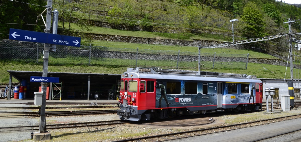 Der Bernina Triebzug ABe 4/4 Nr. 55 mit Werbung f�r RE POWER wartet im Bahnhof Poschiavo auf den n�chsten Einsatz. Ob es links in Richtung Tirano oder nach rechts in Richtung St. Moritz geht ist nicht bekannt. Jedenfalls k�ndigt das L�utewerk am rechten Bildrand jede Zugfahrt an. (16.05.2014)