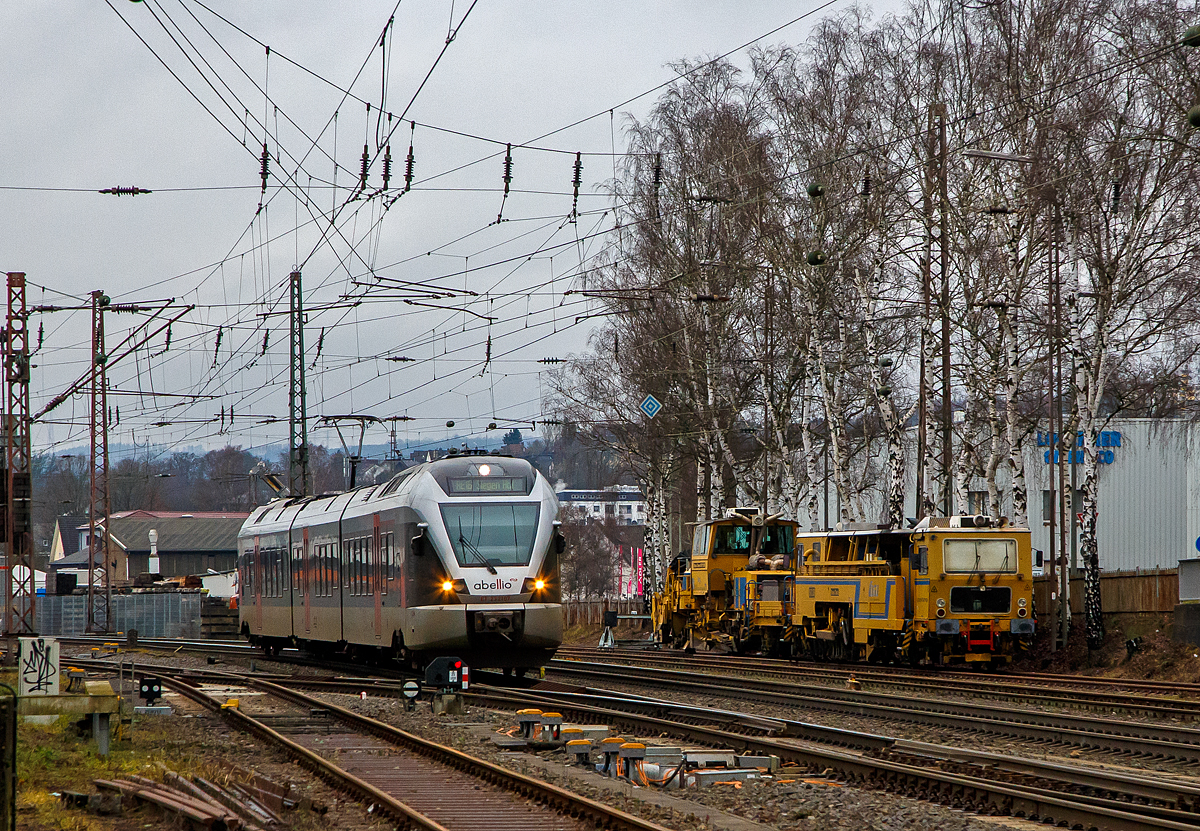 Der ET 23 2107 (94 80 0427 106-0 D-ABRN / 94 80 0827 106-6 D-ABRN / 94 80 0427 606-9 D-ABRN), ex ET 23007, ein 3-teiliger Stadler FLIRT der Abellio Rail NRW GmbH fährt am 29.12.2021, als RB 91  Ruhr-Sieg-Bahn  (Hagen - Finnentrop - Kreuztal – Siegen), von Kreuztal weiter in Richtung Siegen.

Rechts stehen die Plasser & Theurer Zweischwellenstopfmaschine 09 - 32 CSM (Schweres Nebenfahrzeug Nr. D-DGU 99 80 9421 005-6, ex 97 40 68 544 17-6) und die P&T Schotterplaniermaschine SSP 110 SW (Schweres Nebenfahrzeug Nr. D-DGU 99 80 9425 064-9, ex 97 16 40 575 18-1), der DGU - Deutsche Gleisbau Union (Koblenz).
