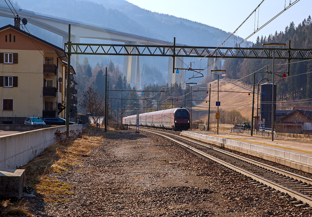 Der ÖBB Railjet (RJX 184), von Bolzano/Bozen via Brennero/Brenner, Innsbruck Hbf und Salzburg Hbf nach Wien Hbf, rauscht am 26.03.2022 Steuerwagen voraus durch den Bahnhof Gossensaß/Colle Isarco in Richtung Brenner. Schublok war die ÖBB Taurus III - 1216 003 / E 190 003 (91 81 1216 003-4 A-ÖBB). 

Im Hintergrund das Wipptal überbrückende Gossensaß-Viadukt (Viadotto Colle Isarco) der Brennerautobahn. Noch fahren auf der Brennerautobahn teilweise LKW an LKW, mit der 2032 geplanten Eröffnung von dem 64 km langen Brennerbasistunnel (BBT), soll dies dann vorbei sein. Dann ist man mit der Bahn von München viel schneller in Verona oder Venedig, aber dann ist für uns Bahnfotografen auch nichts mehr viel los auf der Brennerbahn (Ferrovia del Brennero).