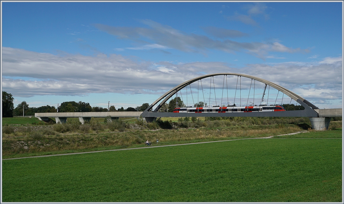 Der Rhein verbindet, der Rhein trennt; doch Brücken überwinden die Trennung. Bei Lustenau, kurz bevor der Rhein in den Bodensee fliest wird der Fluss Alpenrhein genannt, und eine neue Brücke mit einer Stützweite von 102 Meter und der Gesamtlänge, inklusiv der Vorlandtragwerke, von 276 Meter verbindet auf elegante Art das schweizerische St.Margrethen mit dem österreichischen Lustenau, und somit Zürich mit München. Im Bild, auf welchem die ganze Brücke keinen Platz fand, ein ÖBB ET 4024 als Vorarlberger S-Bahn auf der Linie Bregenz - St.Margrethen. 
23. Sept. 2018
