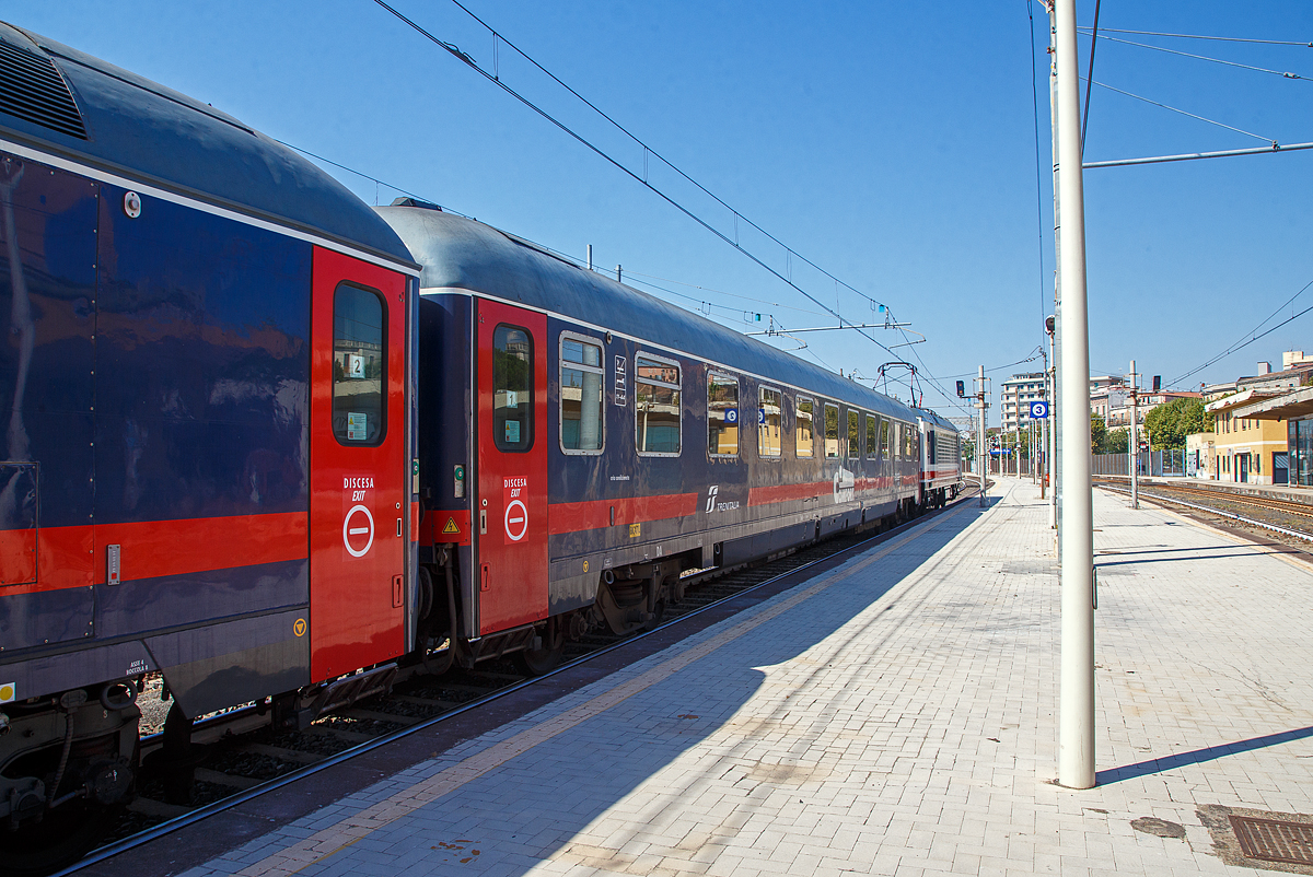 Der Trenitalia intercity notte Comfort Schlafwagen der Gattung Bc, eingereiht als Wagen 1 in den ICN 1959 von Roma Termini nach Syrakus (Siracusa), am 18.07.2022 im Bahnhof Catania Centrale. Diese Wagen haben bis zu 32 Schlafwagenpl�tze (am Tag Sitzpl�tze und in der Nacht Betten). 

TECHNISCHE DATEN: 
Spurweite: 1.435 mm
L�nge �ber Puffer:  26.400 mm
Drehzapfenabstand: 19.000 mm
Sitzpl�tze: 32 (2. Klasse), bzw. bei Nacht Betten
Eigengewicht: 44 t
H�chstgeschwindigkeit:  160 km/h
Bremsbauart:  Freno WU-R 65t