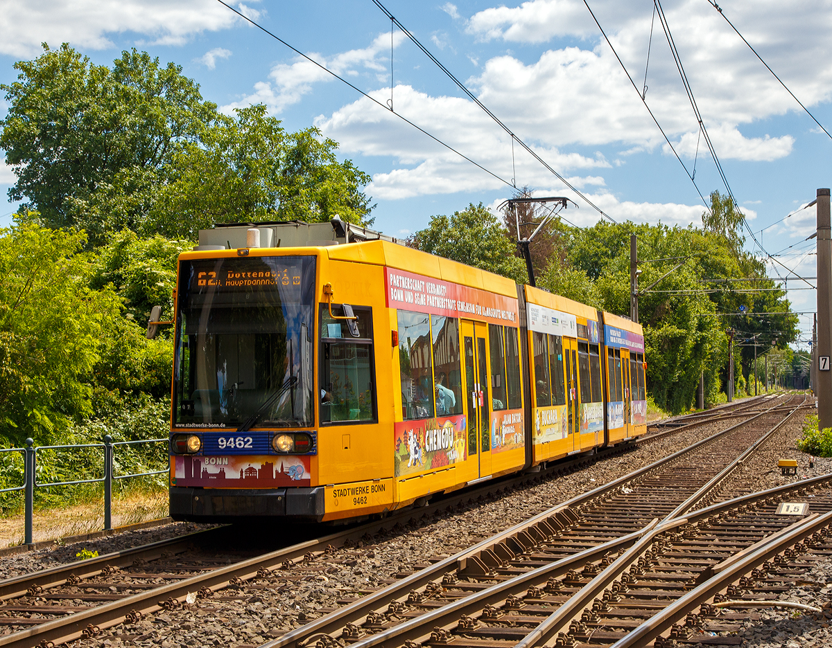 
Der Triebwagen 9462 der SWB (Stadtwerke Bonn Verkehrs GmbH) erreicht am 30.05.2020, als Linie 62 nach Dottendorf, bald die Haltestelle Beuel Bahnhof. Der Zweirichtungs- Niederflur-Gelenktriebwagen ist ein 1993 gebauter DUEWAG-Niederflurwagen vom Typ MGT6D der Bauart NGT6 (6xGlNfTwZR), von der SWB als Typ R1.1 bezeichnet.

Da sich die Strecken nach Dottendorf und Graurheindorf (Auerberg) schlecht für eine Umstellung auf Stadtbahnbetrieb eignen, verfolgten die SWB die Entwicklung der Niederflurtechnik mit großem Interesse. Neben Düsseldorf und Mannheim erhielt man 1991 einen der Prototypen der vom VÖV konzipierten Niederflur-Stadtbahn 2000. Insbesondere die ehrgeizige Technik mit selbstlenkenden Einzelrad-Einzelfahrwerken (EEF) konnte nicht überzeugen. 

Stattdessen wurden 1994 insgesamt 24 Siemens/Düwag R1.1 (NGT6)-Niederflurstraßenbahnwagen mit konventionellen Antriebsdrehgestellen und Einachslaufwerken im Mittelteil beschafft, die seither alle Straßenbahnlinien bedienen. Die Straßenbahnwagen wurden wie bei den meisten Stadtbahnwagen mit neuen orangen LED-Anzeigetafeln und Kundeninformationssystemen ausgestattet, so dass nun auch im Fahrzeuginneren die Ankunft an den nächsten Stationen sowie an der Endhaltestelle ablesbar ist. 

Bis heute haben die R1.1 Triebwagen keine Nachfolger. Da sie sich nach reichlich 20 Jahren Einsatzzeit aber bereits in einem verbrauchten Zustand befinden der die Triebwagen zudem sehr wartungsintensiv macht, sollte in nicht allzu ferner Zukunft mit Ersatz für diese Serie gerechnet werden.

TECHNISCHE DATEN:
Spurweite: 1.435 mm
Bauart: 6xGlNfTwZR
Achsfolge: Bo'+1'1'+Bo'
Gesamtlänge: 28.570 mm 	
Wagenkastenbreite : 2.400 mm
Niederfluranteil: ca. 65 %
Sitzplätze: 72
Stehplätze: 97(4 Pers/m²)
Netzspannung: 	750 V DC Oberleitung
Leistung: 4 x 105 kW
Höchstgeschwindigkeit: 70 km/h
