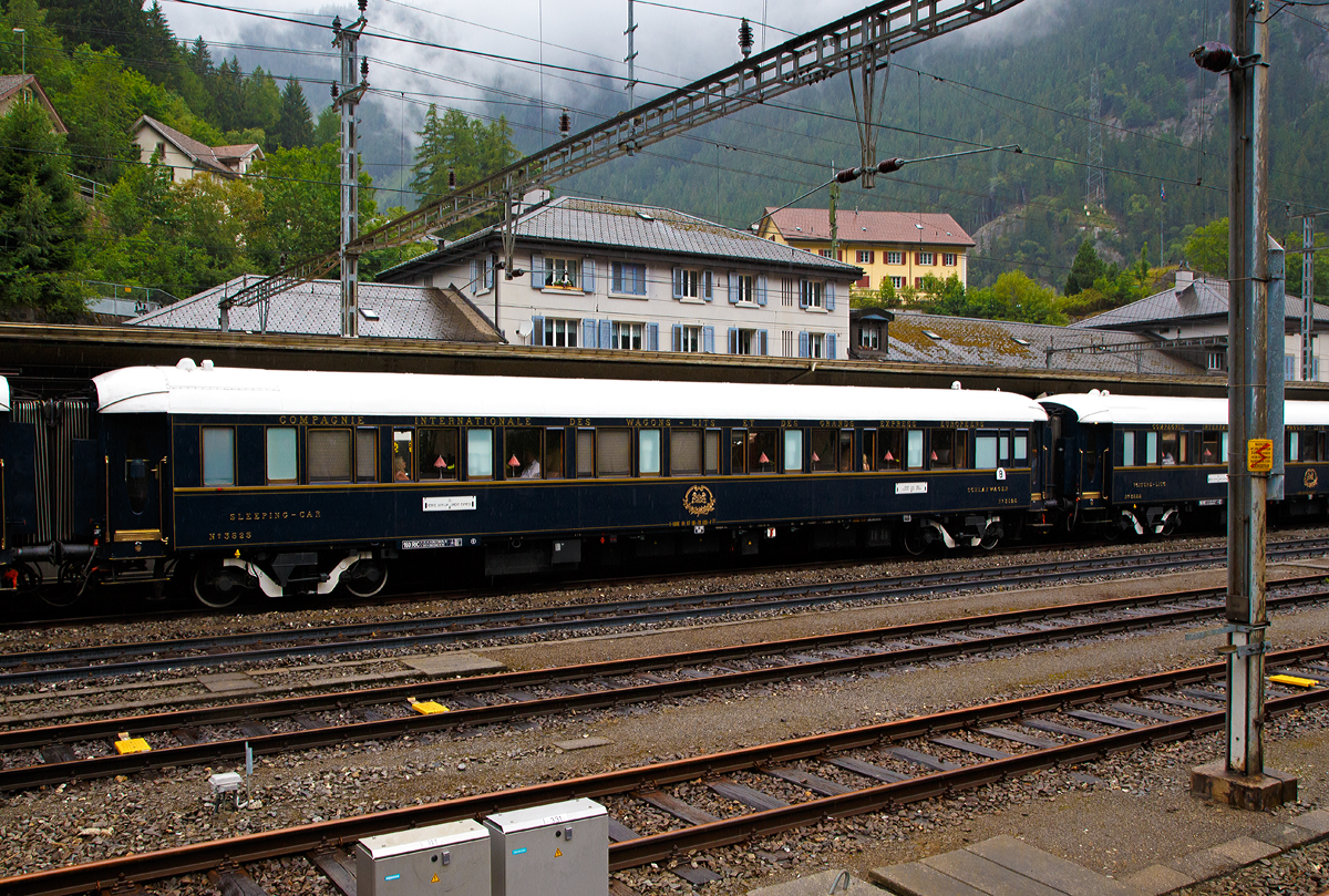 Der VSOE Schlafwagen Nr. 3525 – VSOE Sleeping-Car N� 3525 (F- VSOE 61 87 06-70 525-7) im Zugverbund vom Venice Simplon-Orient-Express am 02.08.2019 beim Halt in G�schenen (CH), leider bei Regen.

Der Schlafwagen, ein CIWL Typ Lx wurde 1929 von Entreprises industrielles des Charentes (EIC, heute zu Alstom geh�rend) in Aytr� (F) gebaut. 

1929 beschaffte die Compagnie Internationale des Wagons-Lits et des Grands Express Europ�ens (CIWL) insgesamt 90 Wagen des neuen Typs Lx (Voiture-Lits de grand luxe). Geliefert wurden die ersten 30 Exemplare von Metropolitan Cammell in Birmingham (GB), die �brigen 60 von der Entreprises industrielles des Charentes (EIC) in Aytr� (F). Die Exemplare aus Birmingham erhielten die Nummern 3466–3495, die Wagen aus Aytr� die Nummern 3496–3555. F�r die Innenausstattung griff die CIWL auf renommierte Designer zur�ck, die in Aytr� produzierten Wagen erhielten ihre Ausstattung durch den franz�sischen Designer Ren� Prou. Die Abteile wurden mit edlen H�lzern wie Mahagoni furniert, teilweise erhielten die Furniere Einlegearbeiten. Die Typ Lx Wagen gelten als die luxuri�sesten je durch die CIWL beschafften Schlafwagen. Von au�en sind die Wagen des Typs Lx vor allem anhand der T�ren von anderen Schlafwagentypen der CIWL zu unterscheiden, diese weisen als einzige ovalen T�rfenster auf, ansonsten findet man sie sonst nur bei den Pullmanwagen.

Technik
Mit der Einf�hrung der Ganzstahlwagen ging die CIWL dazu �ber, von Ausnahmen abgesehen alle Fahrzeuge auf einem einheitlichen Rahmen mit 23.452 mm L�nge �ber Puffer und einem Drehzapfenabstand von 16.000 mm aufzubauen. Die Fahrzeugbreite betr�gt 2.850 mm, die H�he �ber Schienenoberkante 4.000 mm. Auf dieser Basis entstanden neben dem Typ Lx auch die Schlafwagen der Typen S, Y und Z. Die gleichen Rahmen wurden auch f�r Speisewagen und Pullmanwagen verwendet, sie bestehen aus drei L�ngstr�gern mit Querverbindungen und zwei Gussstahlbl�cken an den Enden zur Aufnahme der Zug- und Sto�vorrichtungen. Auf dem Rahmen sind die Seitenw�nde und Fu�b�den sowie die beiden Zustiegsplattformen aufgebaut. Das Gewicht des Typs Lx bel�uft sich auf 53 Tonnen.  Als Drehgestelle erhielten die Wagen urspr�nglich Schwanenhals-Drehgestelle mit Rollenlagern, auch als Pennsylvania-Drehgestelle bezeichnet. Urspr�nglich waren die Wagen lediglich f�r 130 km/h zugelassen, sp�ter nach auf 140 km/h angehoben. 

1977 begann die von James B. Sherwood geleitete Sea Containers Ltd. historische Wagen der CIWL und der British Pullman Company zu erwerben und aufw�ndig zu restaurieren. Die Wagen wurden daf�r �berholt und technisch modernisiert, unter anderem mit Klimaanlagen. Bei den VSOE-Wagen wurde ein Schlafwagenabteil zum Abteil f�r den Schlafwagenschaffner hergerichtet, die Wagen werden seitdem als Typ Lx 18 bezeichnet. Zwischen 2003 und 2006 wurden die Wagen nochmals modernisiert und erhielten unter anderem moderne Drehgestelle von Bombardier sowie neue Klimaanlagen. Seitdem sind die Wagen nun f�r 160 km/h zugelassen. 
