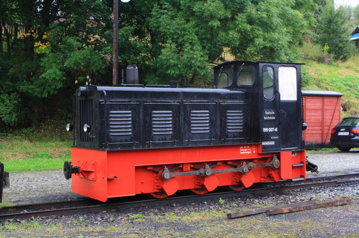 
Die 199 007-6 der Preßnitztalbahn, ex DR 399 701-2, ex DR 199 007-6, ex VEB Feinspinnerei Venusberg Nr. 1, steht am 25.08.2013 in Jöhstadt.

Die LKM Ns 4 b 199 007-6 wurde 1957 vom VEB Lokomotivbau Karl Marx Babelsberg mit der Fabriknummer 250029 hergestellt. Mit Wirkung vom 14. Februar 1958 wurde die Lok mit der Betriebs-Nummer 1 in Venusberg (VEB Feinspinnerei Venusberg) in Dienst gestellt.  Die DR kaufte 1972 die Lok vom VEB Feinspinnerei Venusberg und setzte sie als 199 007-6 bis 1991 in Wilischtal auf der Werkbahn des VEB Papierfabrik Wilischthal (Thumer Netz) ein. 1992 bekam sie nach dem neuem Nummerschema noch Nummer 399 701-2, wurde dann aber an die IG Preßnitztalbahn verkauft. 

Als leistungsstärkste Lokomotive der ersten LKM-Typenreihe besitzt sie einen wassergekühlten 6-Zylinder-Dieselmotor mit 90 PS Nennleistung. Die Kraftübertragung erfolgt vom 4-Gang-Rädergetriebe über Blindwelle und Kuppelstange auf die drei Achsen.
Das Dienstgewicht der Lok beträgt 14,6 Tonnen und die Höchstgeschwindigkeit 24 km/h. Gebremst wird die Lok durch eine Handbremse.

Die NS 4b ist eine Weiterentwicklung der NS 4 und NS 4a, und wurde ab 1957 gebaut. Die drei vorgenannten Typen besitzen alle einen Außenrahmen für Spurweiten von 600 bis 760 mm. Bei der DR gab es mindestens drei Lokomotiven vom Typ Ns 4 b, von denen alle erhalten sind.

TECHNISCHE DATEN:
Hersteller:  LKM Babelsberg
Achsformel:  C
Spurweite:  750 mm
Länge über Puffer:  5.340 mm
Höhe:  2.660 mm
Breite:  1.720 mm
Fester Radstand:  1.800 mm
Dienstmasse:  14,6 t
Höchstgeschwindigkeit:  24 km/h
Installierte Leistung:  66 kW (90 PS)
Anfahrzugkraft:  4,3 Mp
Treibraddurchmesser:  700 mm
Motorentyp:  6 KVD 14,5 SRW
Nenndrehzahl:  1500/min
Leistungsübertragung:  mechanisch
Übersetzungsstufen:  4
