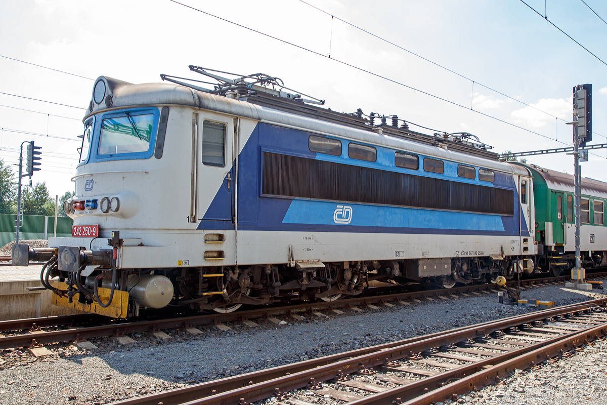 Die 242 250-9 (CZ - ČD 91 54 7 242 250-9), eine reine Wechselstrom E-Lok der tschechischen Česk� dr�hy (ČD), steht am 01.07.2015 mit einem Personenzug im Bahnhof Mari�nsk� L�zně (Marienbad).

Die ČD Baureihe 242 (�koda 73E), ehemals ČSD-Baureihe S 499.02 bzw. ab 1988 Baureihe 242, ist eine elektrische Lokomotive der einstigen Tschechoslowakischen Staatsbahn ČSD f�r das mit 25 kV 50 Hz Wechselstrom elektrifizierte Streckennetz im S�den und Westen der ehemaligen Tschechoslowakei. Sie wurden aus der ČSD S 499.0 entwickelt, von der sie sich vor allem durch einen anderen Lokkasten unterscheidet. W�hrend die S 499.0 einen Lok-Kasten aus glasfaserverst�rktem Kunststoff haben, wurde bei der �koda 73E (S 499.02) der herk�mmlich gefertigte Lokomotivkasten, wie er auch f�r die Gleichstromlokomotiven verwendet wurde, angewandt. Lediglich das f�r die K�hlung des Transformators und die Hochspannungssteuerung n�tige L�fterband wurde anstelle der gro�en Seitenfenster verwendet. Als weitere �nderung haben die Lokomotiven einen Hilfsfahrschalter und eine Einrichtung zur Reduzierung der Achsentlastung bei Zuganfahrten und Fahrten auf Steigungsstrecken. Daf�r erhielten die Lokomotiven spezielle Deichselstangen zwischen den Drehgestellen und eine spezielle Steuerung des Stromrichters. Wie bei der S 499.0 wurde die Lokomotive mit 32 Fahrstufen gesteuert. Lokomotiven dieses Typs wurden auch an die Bulgarische Staatsbahn BD� geliefert.

Von den Lokomotiven der Reihe S 499.02 wurden insgesamt 86 Maschinen bei der ČSD in Dienst gestellt. Mit der am 30. November 1981 ausgelieferten S 499.0286 endete bei �koda die Fertigung der elektrischen Lokomotiven der sogenannten Ersten Generation. Die Lokomotiven sind sowohl vor G�terz�gen als auch vor Schnellz�gen anzutreffen. 1988 wurden die Lokomotiven in die Baureihe 242 umgezeichnet. S�mtliche Lokomotiven gelangten nach 1993 zu den Tschechischen Bahnen ČD und sind dort noch im Einsatz.

TECHNISCHE DATEN:
Herstellertyp: �koda 73E
Baujahre: 1975–1981
Spurweite: 1.435 mm (Normalspur)
Achsformel:  Bo'Bo'
L�nge �ber Puffer: 16.440 mm
Drehzapfenabstand: 7.800 mm
Achsabstand im Drehgestell: 2.800 mm
Dienstgewicht:  86,0 t
Radsatzfahrmasse:  21,5 t
H�chstgeschwindigkeit:  120 km/h
Stundenleistung:  3.200 kW
Dauerleistung:  3.080 kW
Anfahrzugkraft: 240 kN
Stromsystem:  25 kV 50 Hz Wechselstrom
Anzahl der Fahrmotoren:  4
Antrieb:�koda Hohlwellenantrieb

