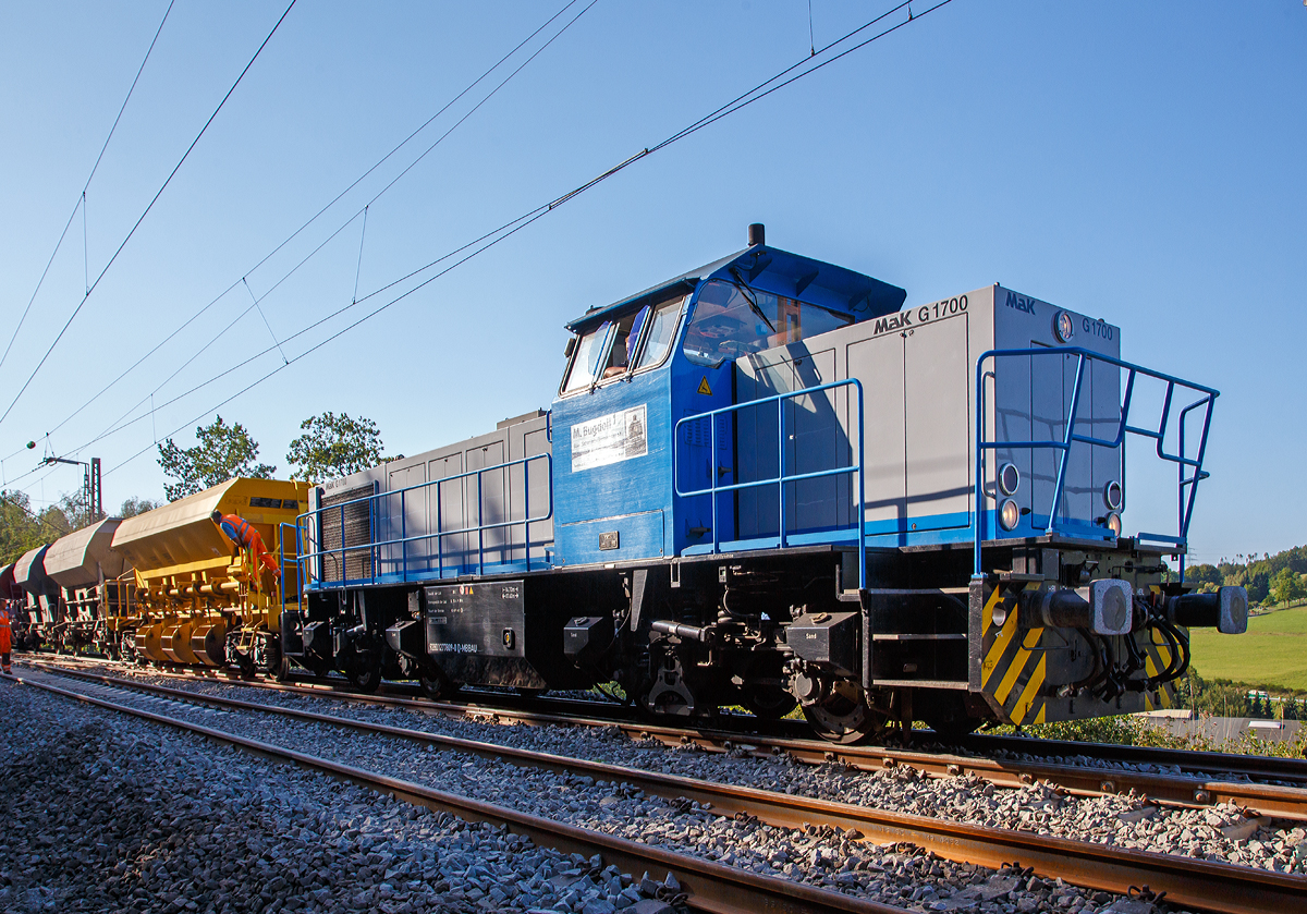 Die 277 809-0  Elmi“ (92 80 1277 809-0 D-MBBAU) der Michael Bugdoll Bau- und Sicherungsarbeiten e. K, ex RHC 277 809-0  Vill , ex NE 277 809-0  Vill  am 24.08.2019 im Bauzugdienst auf der Dillstrecke bei Wilnsdorf-Anzhausen.

Die Vossloh MaK G 1700 BB wurde 2001 von Vossloh in Kiel 2001 unter der Fabriknummer 1001 113 gebaut und an die NE - Neusser Eisenbahn geliefert. Nach dem Zusammenschluss der HGK und der NE zur RheinCargo GmbH & Co. KG, fuhr sie noch als RHC 277 809-0. Anfang 2014 ging sie an die Vossloh Locomotives GmbH (92 80 1277 809-0 D-VL) und war 1 ½ Jahre als Mietlok unterwegs, bis sie im Juni 2015 an die Michael Bugdoll Bau- und Sicherungsarbeiten e. K in Dorsten ging.

TECHNISCHE DATEN:
Spurweite:  1.435 mm
Achsfolge:  B´B´  
Länge über Puffer: 14.700 mm 
Drehzapfenabstand:  7.400 mm 
Achsabstand im Drehgestell:  2.400 mm 
größte Breite:  3.080 mm
größte Höhe über Schienenoberkante:  4.220 mm
Raddurchmesser neu: 1.000 mm
kleinster befahrbarer Gleisbogen:  60 m
Dienstgewicht  87,3 t 
Kraftstoffvorrat  3.500 l
Motor:  MTU-12-Zylinder-Dieselmotor, vom Typ  12V4000R20 
Leistung:  1.500 kW bei 1800 U/min
Getriebe:  Voith L 5r4 zU2 
Höchstgeschwindigkeit : 100 km/h 
Baujahr  2001 - 2003 
gebaute Stückzahl  6

Die Vossloh Lokomotive MaK G 1700 BB ist eine dieselhydraulische Lokomotive. Bei der Überarbeitung der Typenpalette nach der Übernahme der MaK durch Vossloh 1998 wurde im 4. Typenprogramm unter der Bezeichnung G 1700 BB der Bau einer vierachsigen Streckenlokomotive mit Mittelführerhaus vorgesehen. Tatsächlich handelte sich zunächst um eine Weiterentwicklung der G 1206. Die Maschine wurde in einigen Details an die Lokomotiven des 4. Typenprogramms angepasst. Dies betraf in erster Linie den Rahmen, der so geändert wurde, dass die neuen Standarddrehgestelle verwendet werden konnten. Dabei wurden die Rahmenenden so umgestaltet, dass die Lokomotiven die im 4. Typenprogramm üblichen Komfortaufstiege erhielten. Ebenfalls geändert wurde der Dieselmotor. Zum Einsatz kam der schon bei den G 1206 für die Dortmunder Eisenbahn verwendete MTU 12V 4000 R20 mit einer unveränderten Leistung von 1500 kW. Die übrigen Komponenten der G 1700 BB blieben gegenüber der G 1206 weitgehend unverändert.

Die ersten beiden Lokomotiven dieses Typs (die KSW Lok 42 und diese hier) wurden im Jahr 2001 ausgeliefert. Ende 2002 und Anfang 2003 folgten weitere vier Lokomotiven aus Vorratsbauten.

Nach diesen sechs Lokomotiven wurde der Bau der G 1700 BB zugunsten der technisch sehr ähnlichen und bereits weiter verbreiteten G 1206 wieder eingestellt.

Bei der G 1700-2 BB handelt es sich nicht um eine Weiteentwicklung der G 1700 BB, sondern um eine komplette Neuentwicklung.

