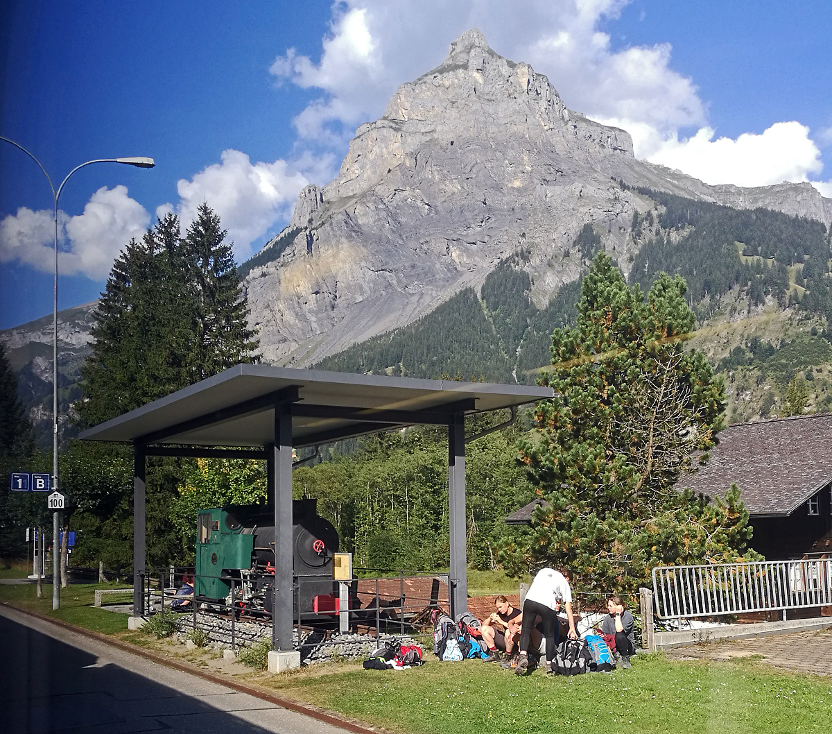 Die 750 mm Jung Dampflok BLS G 2/2 Nr. 1 „Simplon“ als Denkmal auf dem Perron 1 im Bahnhof Kandersteg am 08.09.2021.

Die Lok wurde 1911 von der Lokfabrik Arnold Jung in Jungenthal bei Kirchen an der Sieg unter der Fabriknummer 1684 gebaut und �ber den H�ndler Fritz Marti in Bern an Vanni, Basso & Cie in Frutigen geliefert und war auf der BLS Dienstbahn auf der Nordrampe (Bau L�tschbergtunnel) im Einsatz. Die zweiachsige Lok (B-Kuppler) hatte ein Leistung von 50 PS und ein Leergewicht von 6.1 t.

Nach der Fertigstellung der L�tschbergstrecke der Stammstrecke der  damaligen Bern-L�tschberg-Simplon-Bahn (heute BLS AG) und der Einstellung der Dienstbahnen, war sie f�r den Bau vom Simplontunnel II (zweite R�hre) im Einsatz. 1922 ging sie an die SBB und war bis 1928 beim Bahnhofsumbau in Biel im Einsatz. Sp�ter war sie beim Schiefer-/ Braunkohle Abbau in Zell (Luzern) im Einsatz. Ab1966 war sie im Museum Technorama in Winterthur, bis sie 2010 Gemeinde Kandersteg als Denkmal f�r den Bahnhof Kandersteg �bernommen wurde.

Text: Armin
