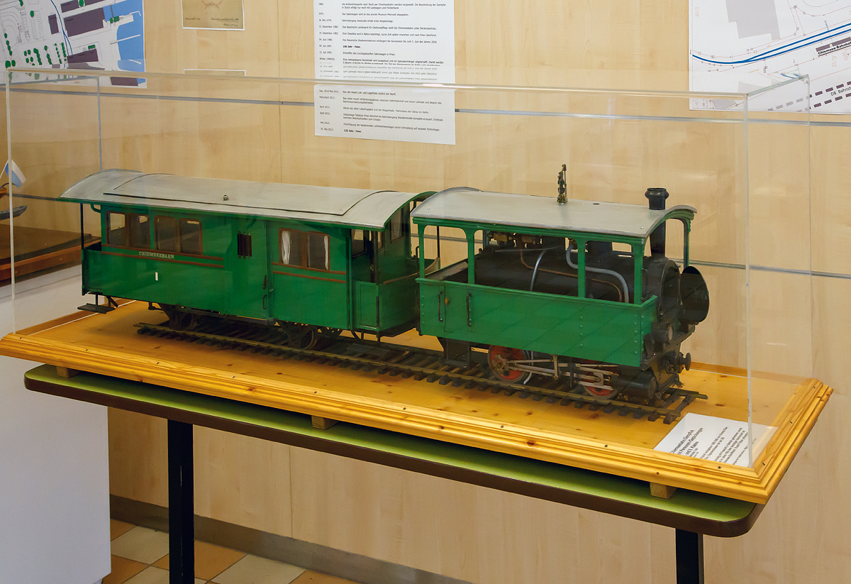 Die älteste betriebsfähige Dampf-Lokomotive der Welt....
Modell der Dampflok Nr. 1  Laura   der Chiemsee-Bahn mit 1. /2 Klasse Personenwagen mit Gepäckabteil, ausgestellt in Prien am Chiemsee (28.12.2016).

Als Ludwig II. im Jahr 1886 starb, ließ dessen Nachfolger Prinzregent Luitpold die Bauarbeiten am Schloss Herrenchiemsee einstellen und gab den Prachtbau für die Öffentlichkeit frei. Dadurch verzeichnete besonders die Herreninsel einen wahren Besucheransturm, aber auch die lieblichere Fraueninsel und die dort ansässigen Gastronomiebetriebe lockten bereits damals viele Touristen an.

Die Königlich Bayerischen Staats-Eisenbahnen brachten die Besucher aus München, Rosenheim und Salzburg nach Prien. Der knapp zwei Kilometer entfernte Hafen konnte vom Bahnhof Prien mit einem von der örtlichen Bevölkerung organisierten Fahrdienst erreicht werden, dieser bestand aus Kutschen und Karren. In der dörflichen Enge entstand dadurch ein erhebliches Verkehrschaos, diese Zustände kannte man zuvor nur aus der „großen Stadt“.

Bereits kurz nach dem ersten großen Ansturm auf Herrenchiemsee beantragten der Schifffahrtbetreiber Ludwig Feßler sowie der Kommerzienrat Georg Krauß aus München (Gründer der Lokomotivfabrik Krauß & Comp.) noch 1886 den Bau einer schmalspurigen Lokalbahn vom Bahnhof Prien zum Dampfersteg in Stock. Planung und Ausführung erfolgten mit einem für die damalige Zeit bemerkenswerten Tempo. Die Bauarbeiten begannen am 2. Mai 1887, schon am 21. Juni waren die Schwellen verlegt und man begann mit dem Aufnageln der Schienen. Die feierliche Eröffnung der Bahn fand nach weniger als 70 Tagen Bauzeit am 9. Juli 1887 statt. Bereits am nächsten Tag, einem Sonntag, nahm sie den offiziellen Betrieb auf. 

Für den Betrieb bestellt man bei der Lokomotivfabrik Krauss & Comp. in München diese L VII Kastenlokomotive (Straßenbahnlokomotive), die 1887 von Krauss & Comp. unter der Fabriknummer 1813 gebaut und an die Chiemsee-Bahn geliefert wurde. Solche zweifach-gekuppelte Nassdampflok vom gleichen Typ, die für den Ein-Mann-Betrieb ausgelegt sind, wurde auch an andere Bahngesellschaften geliefert. 

Seit dem 9. Juli 1887 fährt nun diese Lokomotive bis heute zwischen Prien Bahnhof und Prien Hafen/Stock. Sie ist damit eine der ältesten betriebsfähigen Dampf-Lokomotiven der Welt.

Wesentliche Überholungsarbeiten fanden im Jahr 1937 statt, als eine neue Feuerbüchse aus Kupfer eingepasst werden musste. Im Winter 1957/58 bekam sie einen neuen Kessel von der Lokomotivfabrik Arnold Jung aus Jungenthal bei Kirchen/Sieg. Der schon 1950 unter Fabriknummer 10848 gebaute Kessel fand keinen Abnehmer und wurde so sieben Jahre später in die Chiemsee-Bahn-Lok eingebaut. Der Umbau mit dem neuen Kessel brachte der Lokomotive eine Leistungssteigerung von 60 auf 100 PS (44 auf 74 kW).

Am Anfang besaß sie nur eine einfache Wurfhebel-Handbremse, im Jahr 1961 wurde die Druckluftbremse ergänzt. Seit 1965 besitzt sie eine elektrische Beleuchtung. Nach derzeitigen Bedingungen wird sie in den Sommermonaten nur noch an den Wochenenden eingesetzt.

TECHNISCHE DATEN:
Hersteller: Krauss & Comp., München (Fabriknummer 1813)
Baujahr: 1887
Kessel: Jung, 1950 unter Fabriknummer 10848
Typ: L VII Kastendampflokomotive
Achsfolge: B 
Bauart:  Bn2t
Länge ü. Puffer: 	5.100 mm
Achsstand: 1.800 mm
Höchstgeschwindigkeit: 25 km/h
Indizierte Leistung: 100 PS (ursprünglich 60 PS)
Dienstgewicht:13,3 t
Kohlvorrat: 0,6 t
Wasservorrat: 1,12 m³
Zylinderdurchmesser: 	225 mm
Kolbenhub: 350 mm
Treibraddurchmesser: 800 mm
Kesselüberdruck: 13 bar
Kulissensteuerung:   Stephenson

Lebenslauf: Seit 1887 ununterbrochen bei der Chiemsee-Bahn im Einsatz und somit ältesten betriebsfähigen Dampf-Lokomotive der Welt.

