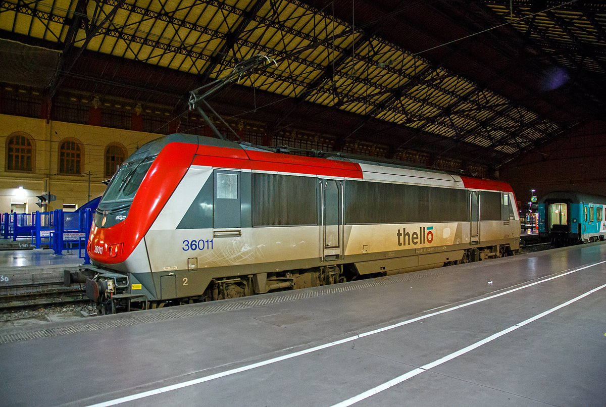 Die an Thello vermietete Akiem 36011 (91 87 0036 011-1 F-AKIEM), eine Alstom BB 36000  Astride  (Asynchron Tricurrent Drive Engine) am 24.03.2015 im Bahnhof Marseille Saint-Charles. Zuvor hatte sie mit dem mit dem Thello EC 159 (Mailand - Genua  - Monte-Carlo - Niza - Toulon - Marseille-St-Charles) ihren Endbahnhof erreicht.

Die Thello S.A.S. mit Sitz in Paris ist französisches Eisenbahnverkehrsunternehmen, das aber der italienischen Trenitalia gehört. Thello war das erste Unternehmen, das die Konkurrenz im Schienenpersonenfernverkehr mit der SNCF aufnahm, nachdem der Markt für internationale Fernverkehrsverbindungen ab 2009 in Frankreich liberalisiert wurde. Thello betreibt Expresszüge zwischen Frankreich und Italien.

Die Lok ist eine BB 36000 welche eine Baureihe von elektrischen Lokomotiven der SNCF, mit dem Kosename  Astride  (Asynchron Tricurrent Drive Engine). Gebaut von Alstom (ehem. GEC-Alsthom), reihen sie sich ein in die Kategorie der europäischen asynchronen Mehrsystem-Lokomotiven. Mit ihren  großen  Schwestern, den BB 26000  Sybic  zählen sie zu den stärksten Lokomotiven der SNCF.

Die Astride besitzen drei unterschiedliche Stromabnehmer (1,5 kV Gleichstrom, 3 kV Gleichstrom und 25 kV 50 hz Wechselstrom). Diese Loks können in Belgien, in Luxemburg, in Italien, in Frankreich und neuerdings sogar in den Niederlanden verkehren. So sollte ein Lokwechsel an den Grenzen vermieden und eine Menge Zeit eingespart werden.

Nach der Bestellung von 264 Lokomotiven der Baureihe BB 26000  Sybic  entschied sich die SNCF für einen Kontraktwechsel. Daher bekamen die letzten 30 Neubau-Lokomotiven eine Drehstromausrüstung mit Asynchron-Motoren. Doch niemand zeigte Interesse an den neuen Loks. Genau zum selben Zeitpunkt wurden nämlich der Personenverkehr vom Güterverkehr bei der SNCF getrennt. Für den Personenverkehr wurde der TGV in den Focus gestellt und die meisten internationalen Nachtzüge abgeschafft. Der Güterverkehr zeigte auch kein Interesse an dieser polyvalenten Lok. Ebenfalls zu diesem Zeitpunkt, begann Alstom mit der Entwicklung der Prima, von der sie sich höhere Renditen erhoffte, sowohl in Frankreich, als auch im Ausland. Unter diesen Umständen war es schwer für die „Astride“ sich durchzusetzen, zu allem Übel litt sie auch noch lange unter verschiedenen Kinderkrankheiten.

Die insgesamt 60 gebauten BB 36000 „Astride“ wurden zwischen 1996 und 2002 ausgeliefert. Sie können eine gewisse Familienzugehörigkeit mit den BB 26000 nicht verleugnen, auch wenn die Ecken etwas abgerundet wurden und sie aerodynamischer ist, als die Sybic.

Obwohl sie Personenzüge mit 200, ja sogar 220 km/h ziehen kann, so wurde die „Astride“ doch vorwiegend im Güterverkehr zwischen Belgien und Italien eingesetzt. Dort ist ihre Geschwindigkeit allerdings auf 120 km/h begrenzt.

Im Oktober 2011 kamen die Loks mit den Nummern BB 36001,2,4,5,7,11 und 15 zu Akiem. Sie behielten zwar ihre  livrée multiservice , haben aber das SNCF Logo verloren. Drei von diesen Loks (BB36007, BB36011, BB36015) wurden bis 200 km/h getestet und fahren jetzt im internationalen Personenverkehr zwischen Paris und Venedig, sowie Marseille und Mailand. Diese Verbindungen werden von Thello, einer Tochtergesellschaft von Veolia betrieben.

Technische Daten der Baureihe BB 36000  Astride :
Betriebsnummern : 36001-36030, die 36331-36360 Italien tauglich, Mehrfachtraktion
Hersteller: GEC-Alsthom
Spurweite: 1.435 mm
Bauart: Bo'Bo'
Stromsystem: 1.500 V DC; 3.000 V DC und 25 kV, 50 Hz AC
Baujahre: 1996-2002

Länge über Puffer: 19.110 mm
Achsabstand im Drehgestell: 3.000 mm
Drehzapfenabstand: 10.400 mm
Breite: 2.926 mm
Höhe: 4.270 mm
Dienstgewicht: 89 t
Triebraddurchmesser (neu): 1.150 mm
Höchstgeschwindigkeit: 200 km/h (wenige 220 km/h)
Dauerleistung: 5.600 kW
Anfahrzugkraft: 320 kN
Anzahl der Fahrmotoren: 4 (4 FXA 4559 Alstom Asynchronmotoren mit Zwangsbelüftung)