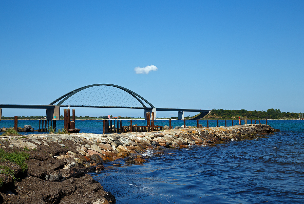Die Fehmarnsundbrücke am 12.06.2015 aufgenommen von  Grossenbroder Fähre, rechts die Insel Fehmarn.

Die Fehmarnsundbrücke ist eine kombinierte Straßen- und Eisenbahnbrücke, die die Insel Fehmarn in der Ostsee mit dem Festland bei Großenbrode verbindet, sie wurde 1963 eröffnet. 

Die 963 Meter lange Brücke überspannt den 1300 Meter breiten Fehmarnsund, wobei die restlichen 337 Meter aus beidseitigen Rampen bestehen. Sie hat eine lichte Höhe von 23 Metern über dem Mittelwasser und bietet für den Schiffsverkehr einen Durchgang von 240 Metern Breite sowie eine Durchfahrtshöhe von 23 Metern über NN. Sie ist eine Stahlkonstruktion mit 21 Metern Breite, von denen sechs Meter von der Deutschen Bahn genutzt werden. Der zirka 268,5 Meter lange Bogen hat eine Stützweite von 248 Metern und ist mit 45 Metern über der Fahrbahn höchster Punkt. Nach einer Festen Fehmarnbeltquerung, welche gebaut wird, ist die vorhandene Fehmarnsundbrücke den höheren Belastungen nicht mehr gewachsen.

Bis 1963 existierte eine Eisenbahnfähre von Großenbrode Fähre über den Fehmarnsund bis zum gleichnamigen Ort Fehmarnsund auf der Insel Fehmarn. Für die Verbindung nach Dänemark gab es, von 1951bis 1963 die Eisenbahnfähre (Trajektverkehr) vom Bahnhof Großenbrode Kai (D) nach Gedser (DK). Nach Fertigstellung der Fehmarnsundbrücke und der Eröffnung der Vogelfluglinie wurde der Trajektverkehr auf Puttgarden (D)und Rødbyhavn (DK) verlegt. Zum 14. Dezember 2019 wurde die Eisenbahnfährverbindung auf der Vogelfluglinie aufgrund von Gleisarbeiten auf dänischer Seite im Zuge des Baus des Fehmarnbelttunnels eingestellt.
So ist heute die Verbindung Rostock (D) nach Trelleborg in Schweden die letzte Eisenbahnfährverbindung in Deutschland, wobei hier nur Güterverkehr stattfindet. 
