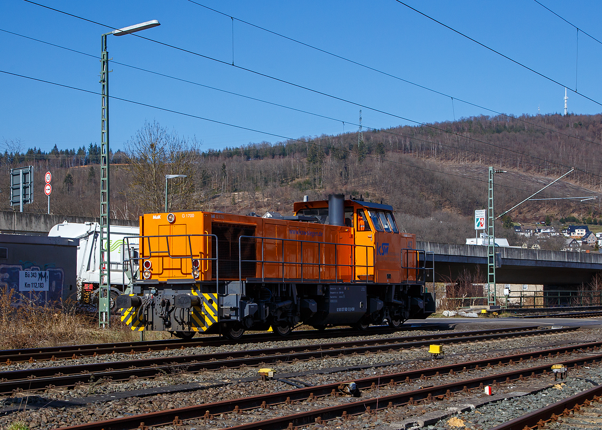 Die KSW 42 bzw. 277 902-3 (92 80 1277 902-3 D-KSW) der KSW (Kreisbahn Siegen-Wittgenstein), fährt am 24.03.2021 als Tfzf (Triebfahrzeugfahrt) bzw. Lz (Lokzug) durch Niederschelden in Richtung Betzdorf (Sieg). Nach dem Umsetzen in Betzdorf fährt sie dann nach Herdorf.

Die Lok ist eine Vossloh MaK G 1700 BB sie wurde 2001 unter der Fabriknummer 1001108 bei Vossloh gebaut, und war die erste gebaute G 1700 BB.

Die Vossloh Lokomotive MaK G 1700 BB ist eine dieselhydraulische Lokomotive. Bei der Überarbeitung der Typenpalette nach der Übernahme der MaK durch Vossloh 1998 wurde im 4. Typenprgramm unter der Bezeichnung G 1700 BB der Bau einer vierachsigen Streckenlokomotive mit Mittelführerhaus vorgesehen. Tatsächlich handelte sich zunächst um eine Weiterentwicklung der G 1206. Die Maschine wurde in einigen Details an die Lokomotiven des 4. Typenprgramms angepasst. Dies betraf in erster Linie den Rahmen, der so geändert wurde, dass die neuen Standarddrehgestelle verwendet werden konnten. Dabei wurden die Rahmenenden so umgestaltet, dass die Lokomotiven die im 4. Typenprgramm üblichen Komfortaufstiege erhielten. Ebenfalls geändert wurde der Dieselmotor. Zum Einsatz kam der schon bei den G 1206 für die Dortmunder Eisenbahn verwendete MTU 12V 4000 R20 mit einer unveränderten Leistung von 1500 kW. Die übrigen Komponenten der G 1700 BB blieben gegenüber der G 1206 weitgehend unverändert.

Die ersten beiden Lokomotiven dieses Typs wurden im Jahr 2001 ausgeliefert. Ende 2002 und Anfang 2003 folgten weitere vier Lokomotiven als Vorratsbauten.

Nach diesen sechs Lokomotiven wurde der Bau der G 1700 BB zugunsten der technisch sehr ähnlichen und bereits weiter verbreiteten G 1206 wieder eingestellt.

Bei der G 1700-2 BB handelt es sich nicht um eine Weiteentwicklung der G 1700 BB, sondern um eine komplette Neuentwicklung. 

Technische Daten
Spurweite:  1.435 mm
Achsfolge:  B´B´  
Länge über Puffer: 14.700 mm 
Drehzapfenabstand:  7.400 mm 
Drehgestellachsstand:  2.400 mm 
größte Breite:  3.080 mm
größte Höhe über Schienenoberkante:  4.220 mm
Raddurchmesser neu: 1.000 mm
kleinster befahrbarer Gleisbogen:  60 m
Dienstgewicht  87,3 t 
Kraftstoffvorrat  3.500 l
             
Motor:  MTU-12-Zylinder-Dieselmotor, vom Typ  12V4000R20 
Leistung:  1.500 kW bei 1800 U/min
             
Getriebe:  Voith L 5r4 zU2 
Höchstgeschwindigkeit : 100 km/h 
             
Baujahr  2001 - 2003 
gebaute Stückzahl  6
