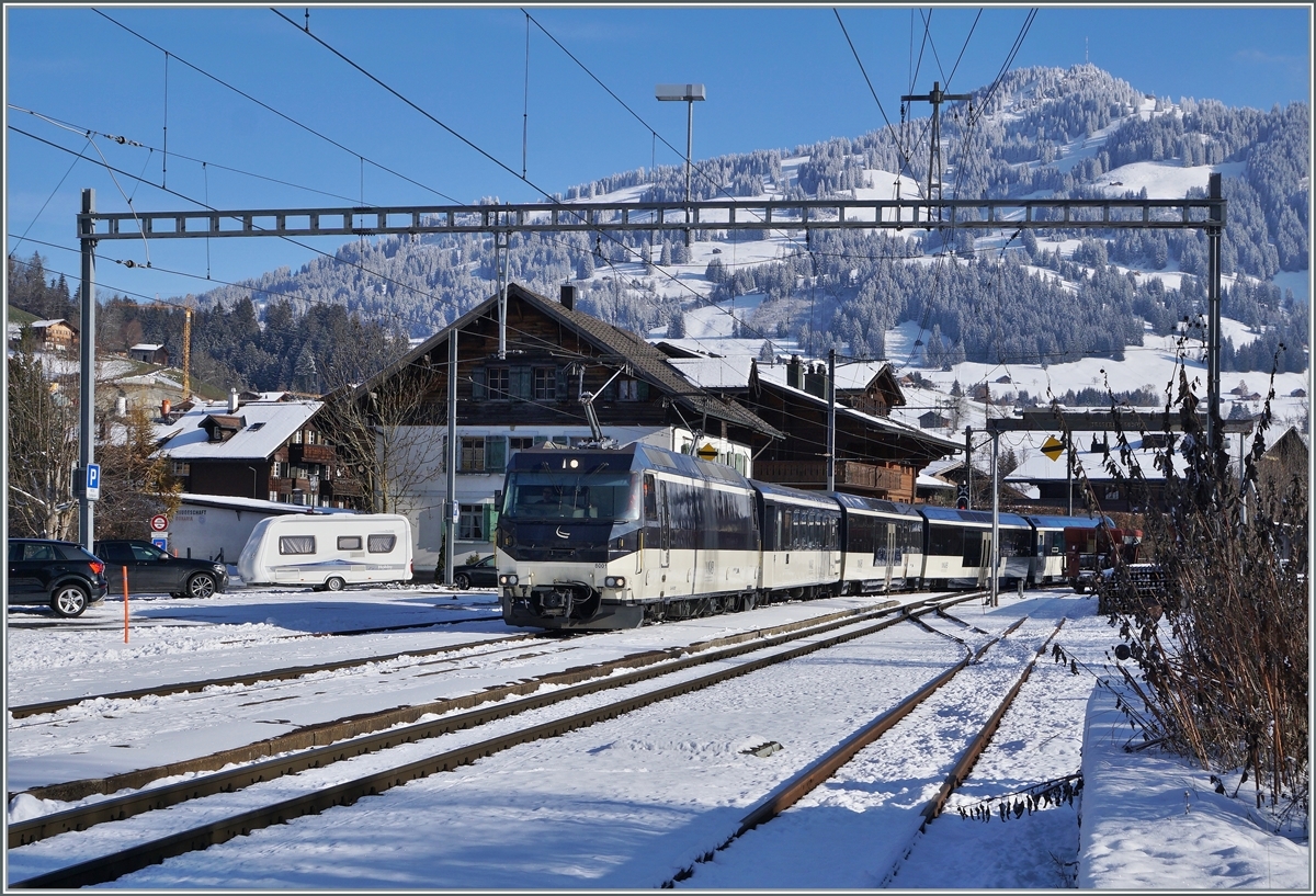 Die MOB Ge 4/4 8001  erreicht mit ihrem Reisezug nach Montreux den Bahnhof von Saanen. 

3. Dez. 2020