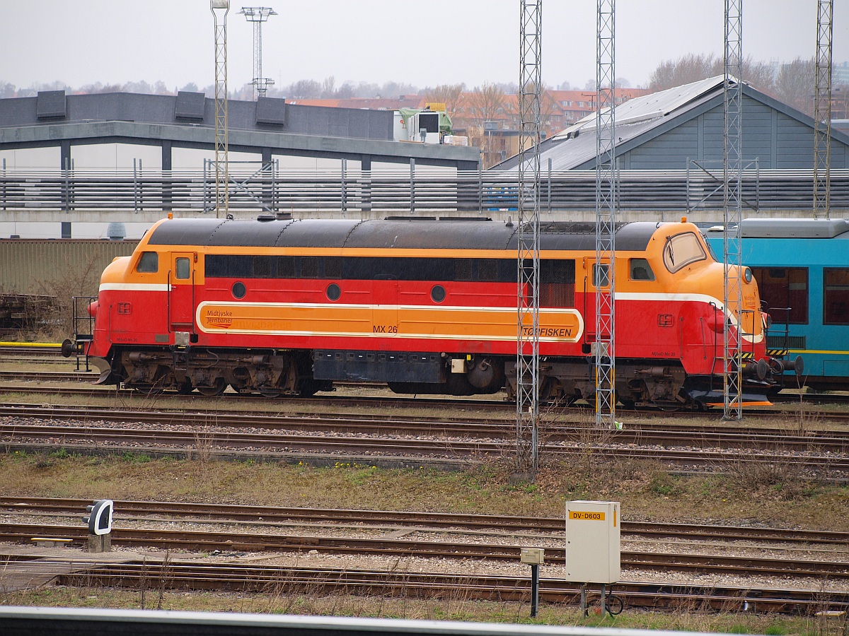 Die Mx 26  Tørfisken  der Midtjyske Jernbaner(gebaut 1961 als Mx 1025 für die DSB)steht hier abgestellt in Aarhus. Es ist nicht möglich gewesen die Lok mit weniger Masten im Bild zu fotografieren. 20.04.2010