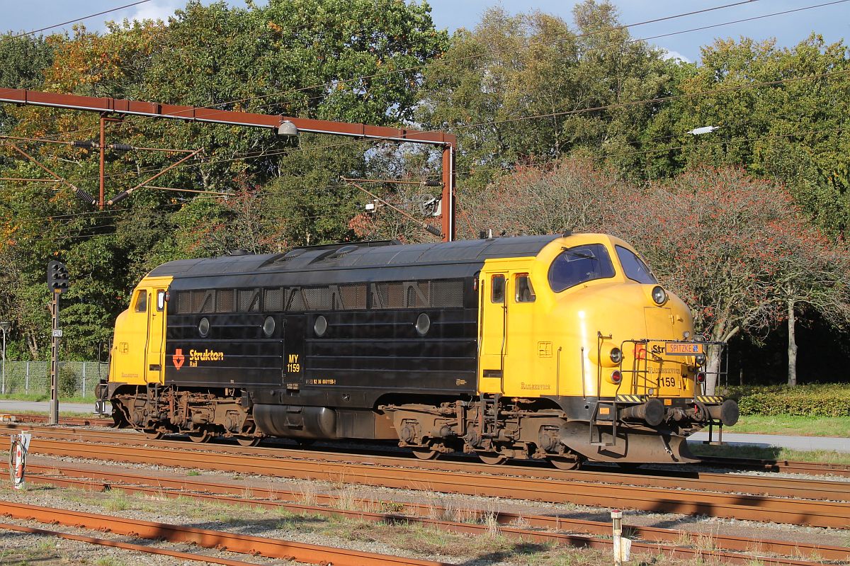 Die MY 1159 wurde als letzgebaute MY am 15.6.1965 von NoHAB an die DSB abgeliefert.
Ab 2001 fuhr sie als offizielle DSB Museumslok, bis sie 2019 von Strukton Rail/Pailservice übernommen und gelb/schwarz lackiert wurde. Ab diesem Zeitpunkt wird sie im Bauzugdienst eingesetzt und ist in Pattburg stationiert.
Hier wartet sie am 06.10.2021 in Pattburg auf Ausfahrt gen Norden.