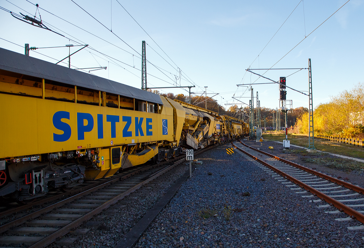 Die Plasser & Theurer Planumssanierungs- und Reinigungsmaschine RPM-RS-900 „Katharina die Große“ der SPITZKE SE (Großbeeren), Schweres Nebenfahrzeug Nr. D-SPAG 99 80 9415 004 – 1 (ex 97 19 35 501 18-1), am 09.11.2021 bei einer Zugdurchfahrt in Betzdorf (Sieg) in Richtung Siegen.

Hier als Detailbild (2) die Aushubmaschine, (P&T Fabriknummer 4798), hinter der Kabine 3 die Schotteraushubkette (1. Aushubkette) und nach dem dreiachsigen Drehgestell folgt dann die Planumaushubkette (2. Aushubkette), die max. Aushubtiefe beträgt bis zu 1.200 mm von der SO. Im Einsatz ist übt das dreiachsigen Drehgestell keinen Achsdruck aus, sondern das Gleis dort verriegelt und hochgehalten. 
