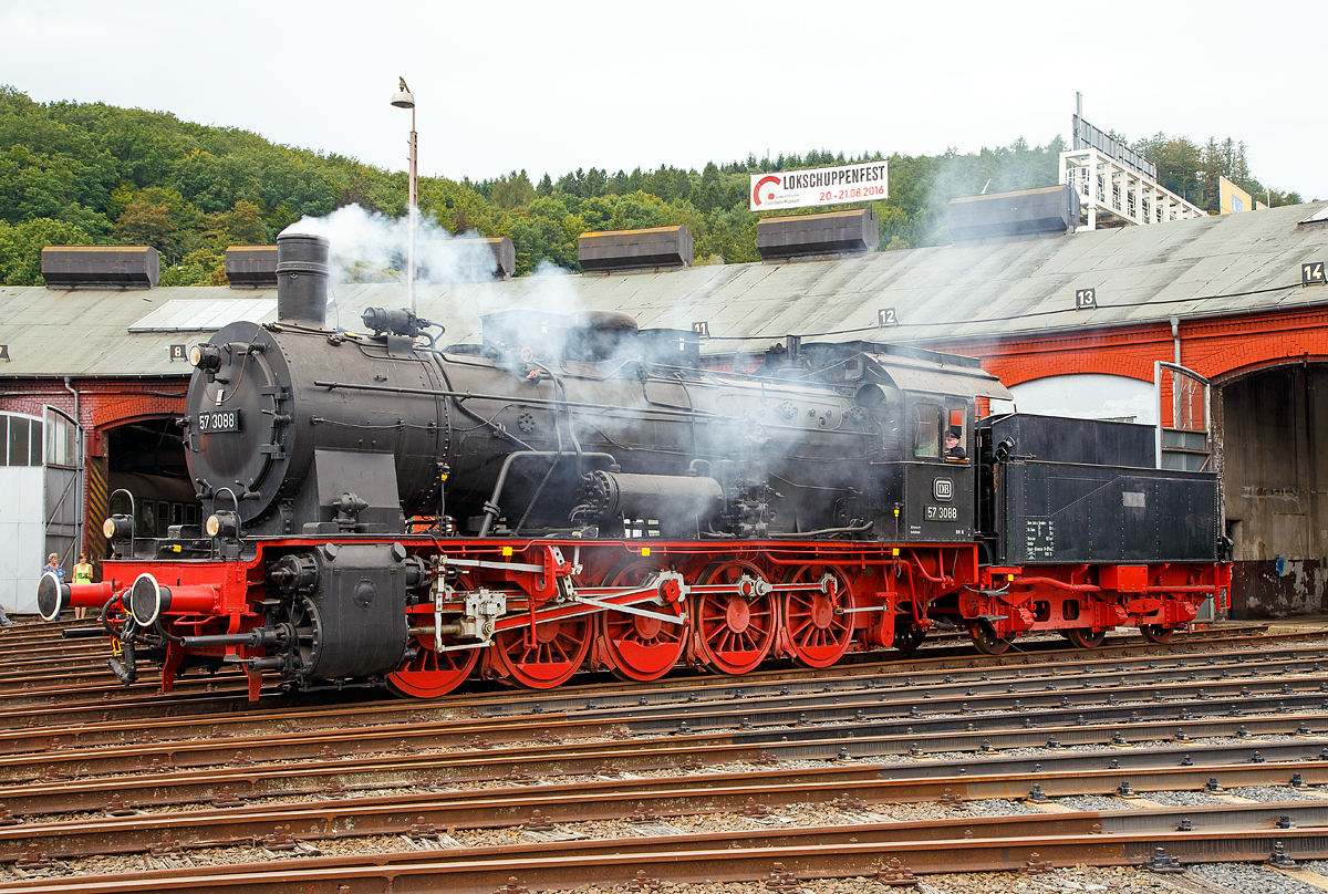 
Die preuß. G10 Schlepptender-Güterzuglokomotive 57 3088 (ex G10 6011 Halle, ex DB 057 088-7) wird am 20.08.2016 beim Lokschuppenfest vom Südwestfälischen Eisenbahnmuseums in Siegen vor dem Ringlokschuppen präsentiert. Dass sie hier raucht verdankt sie der Tatsache, dass mit einer Nebelmaschine nachgeholfen wurde.

Die Lok wurde 1922 von Rheinmetall unter der Fabriknummer 550 gebaut und als G10 6011 Halle an die Deutsche Reichsbahn geliefert, 1925 erfolgte die um Bezeichnung in DR 57 3088 (nach dem Krieg DB 57 3088). Kurz vor der z-Stellung am 10.06.1968 wurde sie zum 01.01.1968 noch in DB 057 088-7 umgezeichnet. Am 24.06.1970 schied sie aus dem Bestand der DB aus. Von 1974 bis 2002 war sie als Denkmal auf dem Gelände des Bahnbetriebswerks Haltingen aufgestellt (mit Unterbrechungen als Ausstellungstück). Nachdem der Personalbestand in Haltingen zur Pflege gemäß den Auflagen des VM Nürnberg nicht mehr ausreichte, kam sie 2002 nach Siegen.

Die Preußische G 10 war eine Güterzug-Schlepptenderlok, die auf Basis des Fahrgestells der Preußischen T 16 und des Kessels der Preußischen P 8 entwickelt wurde.
Bei der Entwicklung der G 10 wurde das Fahrwerk der T 16 mit der seitenverschiebbaren ersten und fünften Achse deutlich modifiziert - die T 16 wurde danach mit diesem modifizierten Fahrwerk als T 16.1 weiter-gebaut. Die G 10 war für den schweren Güterzugdienst auf Hauptstrecken vorgesehen, durch ihre niedrigere Achslast konnte sie aber flexibler als die in etwa leistungsgleiche Preußische G 8.1 eingesetzt werden. Die G 10 wurde vereinzelt sogar auch im Personenzugdienst verwendet.
