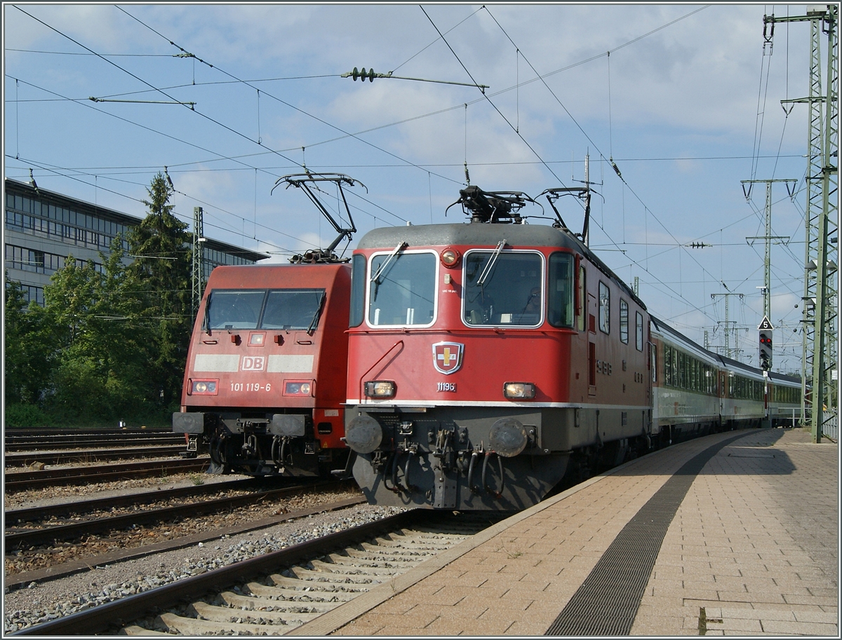 Die Re 4/4 II 11196 erreicht mit ihrem IC 282 von Zürich nach Stuttgart den Bahnhof Singen. Auf dem Nebengleis wartet schon die DB 101 119-6 welche den Zug ab Singen übernehmen wird.
2. August 2015