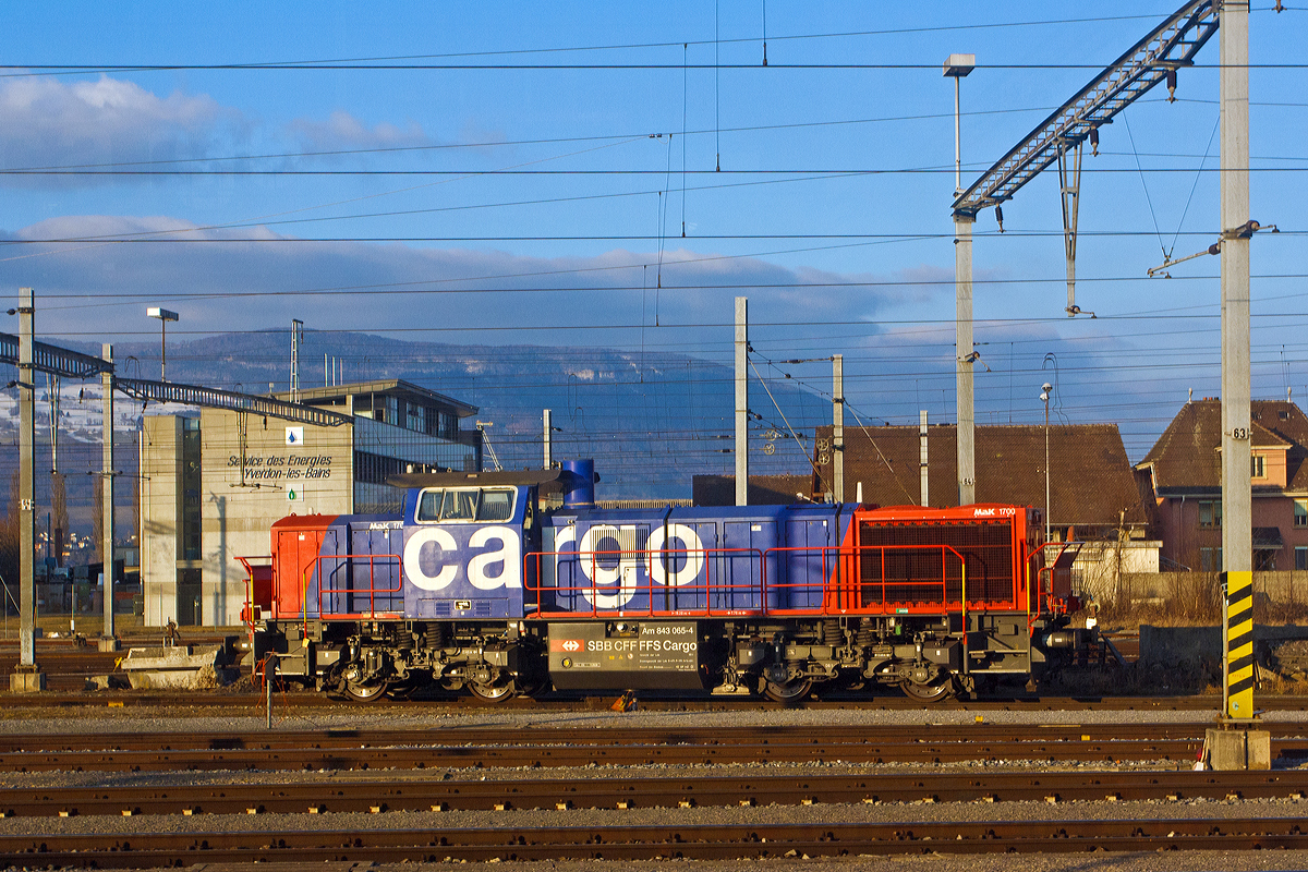 
Die SBB Cargo Am 843 065-4 (MaK 1700), abgestellt am 25.02.2012 beim Bahnhof Yverdon-les-Bains, aufgenommen aus einem fahrenden ICN. 

Die Lok wurde 2004 unter der Fabrik-Nr. 1001409  bei Vossloh in Kiel (ehem. MaK) gebaut. Die Am 843 verf�gt �ber einen Mikropartikelfilter und gilt als eine der saubersten Diesellokomotiven. Die Am 843 basiert auf den dieselhydraulischen Standardlokomotiven des Typs G 1700-2 BB des Kieler Schienenfahrzeugherstellers Vossloh, ist aber im Gegensatz zur Standard-Version auf den in der Schweiz �blichen Linksverkehr ausgelegt. 

Technische Daten:
Spurweite:  1.435 mm 
Achsfolge:  B´B´
L�nge �ber Puffer: 15200 mm
Drehgestellmittenabstand:  7.700 mm
Drehgestellachsstand: 2.400 mm
gr��te Breite:  3.080 mm
gr��te H�he �ber Schienenoberkante:  4.220 mm
Raddurchmesser neu:  1.000 mm
kleinster befahrbarer Gleisbogen:  60 m
Dienstgewicht:  80 t
Kraftstoffvorrat: 3500 l
Motor :   Caterpillar 12-Zylinder-4Takt-Dieselmotor mit Abgasturbolader und Ladeluftk�hlung vom Typ 3512 B DI-TA-SCAC. Mit 322 Liter Schmier�l und 134 Liter K�hlwasser  hat der Motor ein Gewicht von 7.700 kg.
Leistung: 1.500 kW (2.040 PS)
Drehzahl:  1.800 U/min
Getriebe:  Voith L 5r4 zseU2 
H�chstgeschwindigkeit:  40 km/h im Rangiergang / 100 km/h  im Streckengang
