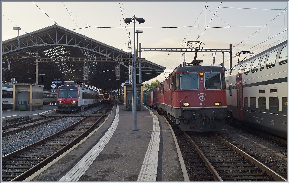 Die SBB Re 4/4 II 11172 und eine weitere Re 4/4 II warten mit dem EN Thello nach Paris in Lausanne auf die Weiterfahrt. Links im Bild verlässt ein Domino als S 12014 nach Vallorbe Lausanne.  
1. Juni 2018