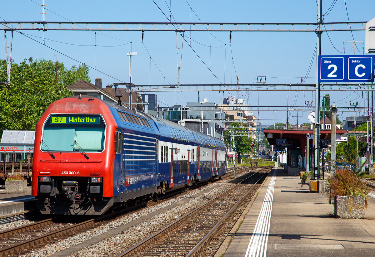 Die SBB Re 450 000-5  Seebach , ex Re 4/4 450 000, schiebt einen Doppelstock-Pendelzug (der erste Generation) Zürcher S-Bahn als S7 nach Winterthur in den Bahnhof Zürich-Tiefenbrunnen. 

Die Lok wurde als Re 4/4 V - 10500 bestellt, bei der Auslieferung 1989 wurde sie aber schon als Re 450 000-5 bezeichnet. Sie war die erste von 115 Stück gebauten Loks.

Aufgrund des Pendelzugbetriebs wurde auf einen zweiten Führerstand verzichtet und der gewonnene Platz für ein Gepäckabteil genutzt. Äußerlich wurden Loks  an den Doppelstock-Pendelzugs (DPZ) angeglichen und mit entferntem zweitem Führerstand erinnert nichts daran, dass die Re 450 technisch weitgehend den ab 1987 von SLM/BBC für Privatbahnen gebauten Re 456 entspricht. Das Fahrwerk ist allerdings eine Neuentwicklung von SIG. Die Re 450 ist die erste Lok in großer Serie von Umrichterlokomotiven mit GTO-Thyristoren und Drehstrom-Asynchronmotoren, welche bei der SBB im Einsatz kamen. 

Zwischen 1989 und 1997 wurden insgesamt 115 Stück der Re 450 von SLM/ABB gebaut. Die erste Serie von 24 Lokomotiven wurde noch unter der Bezeichnung Re 4/4V (10500 – 10523) bestellt, trug bei Auslieferung allerdings bereits die neue Bezeichnung Re 4/4 450 (450 000 – 450 023) unter welcher auch die zweite Serie von 26 Maschinen (450 024 – 450 049) abgeliefert wurde. Zwischenzeitlich änderte die SBB die Baureihen- und Betriebsnummern erneut, und die Lokomotiven erhielten ihre heute noch unverändert gültige Baureihenbezeichnung Re 450. Aufgrund der starken Auslastung der SLM durch den Bau der SBB Re 460, welche 1992 in großem Stil anlieft, wurden die 45 Lokomotivkästen der dritten Serie (450 050 – 450 094) von Schindler Waggon (SWP/SWG) aus dem Werk Pratteln geliefert. Die vierte und letzte Serie von nochmals 20 Maschinen (450 095 – 450 114) wird ab 1996 geliefert – nach Abschluss der Auslieferung der Re 460. Bei diesen Maschinen wurde wieder der Lokkasten von SLM gebaut, während die ABB Verkehrstechnik, inzwischen unter dem Namen Adtranz, erneut die elektrische Ausrüstung liefert.

Die zugehörigen Doppelstockwagen wurden im selben Zeitraum von Schindler Waggon (Wagenkasten, mechanische Teile), SIG (Fahrwerk) und ABB respektive Adtranz (elektrische Ausrüstung) gebaut. Eine Re 450-Pendelzugskomposition besteht generell aus einem AB- und einem B-Wagen sowie einem Steuerwagen (Bt).

Die Re 450 und die zugehörigen DS-Bt verfügen über automatische Kupplungen vom Typ +GF+ Vorortsbahnkupplung (GFV) und werden im Normalbetrieb jeweils kompositionsweise über die automatische Kupplung gekoppelt. Die Vielfachsteuerung erlaubt das gemeinsame Führen von bis zu vier Pendelzugkompositionen. Da die Nutzlänge der Perrons auf dem Zürcher S-Bahn-Netz in der Regel auf maximal 320 m beschränkt ist, wurde die Anzeige- und Diagnoseebene der Führerstände auf nur drei Einheiten ausgelegt.

Im Zuge des Modernisierungsprogrammes „Lion“ werden die Re 450 im Industriewerk Yverdon (zwischen 2011–2018) grundlegend saniert, die 450 000-5 ist noch nicht modernisiert.
 • Folgende Arbeiten werden ausgeführt:
 • Rostsanierung und Neulackierung
 • Ersatz der Fahrmotorrotoren und Neuwicklung der Statoren
 • Ersatz der Getriebekästen
 • Ersatz der Frontbeleuchtung durch LED-Beleuchtung
 • Ertüchtigung der Traktionsstromrichter
 • Ersatz der Geschwindigkeitsmessanlage mit integrierten Sicherheitssystemen und Fahrdatenregistrierung
 • Nachrüstung Druckluftanlage mit Lufttrockner und automatischem Wasser-/Ölabscheider

TECHNISCHE DATEN:
Gebaute Anzahl: 115 (Re 450 000 bis 114)
Spurweite: 	1435 mm (Normalspur)
Achsformel:  Bo'Bo'
Länge über Puffer: 18.400 mm
Höhe:  4.500 mm
Breite:  2.980 mm
Leergewicht:  74 t
Nutzlast (Gepäckanteil):  4 t
Höchstgeschwindigkeit: 130 km/h
Dauerleistung:  3.200 kW
Anfahrzugkraft:  240 kN
Kupplungstyp: GFV (front), Schraubenkupplung (zu den Wagen)
